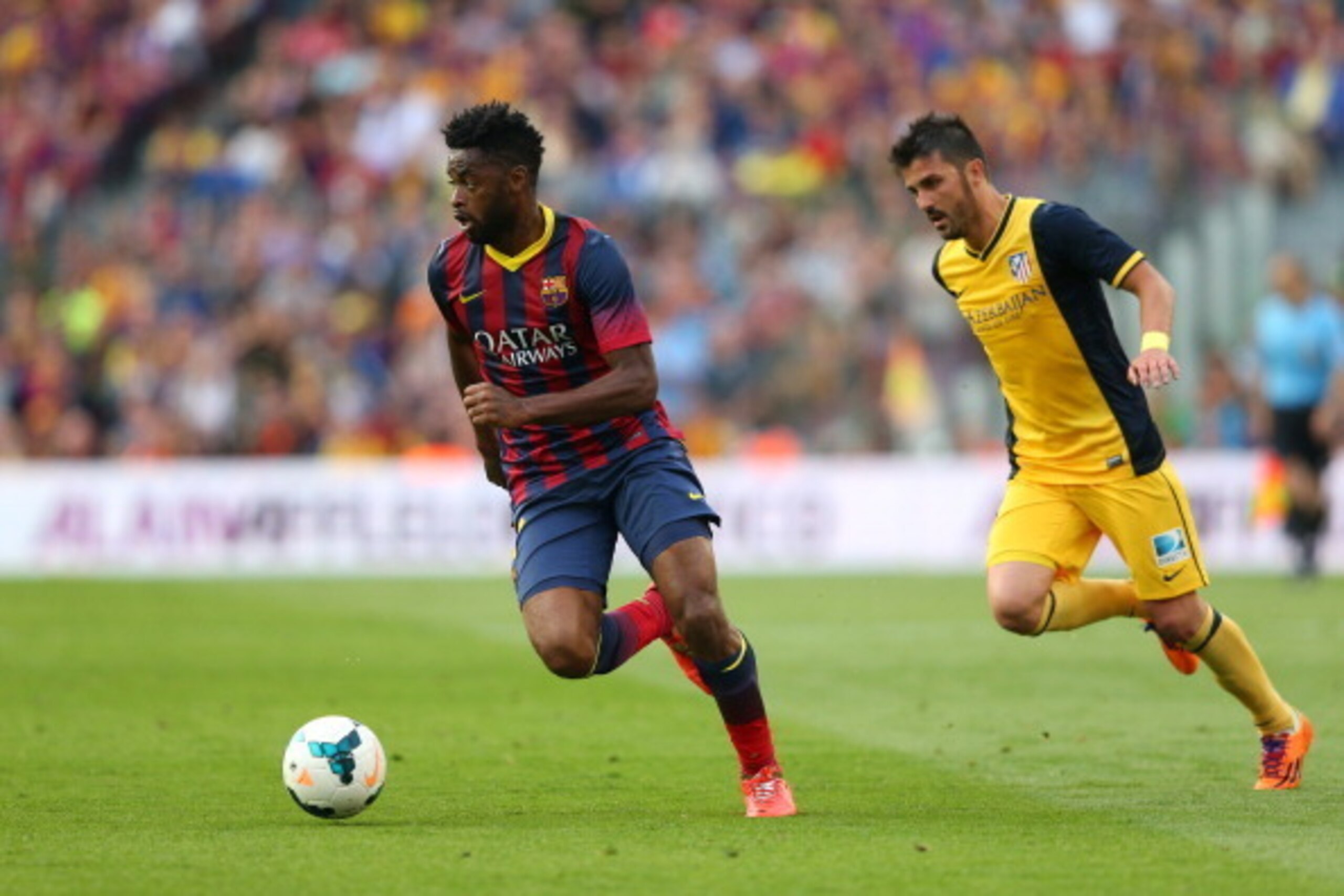 BARCELONA, SPAIN - MAY 17: Alex Song of FC Barcelona beats David Villa of Club Atletico de Madrid during the La Liga match between FC Barcelona and Club Atletico de Madrid at Camp Nou on May 17, 2014 in Barcelona, Spain.  (Photo by Alex Livesey/Getty Imag