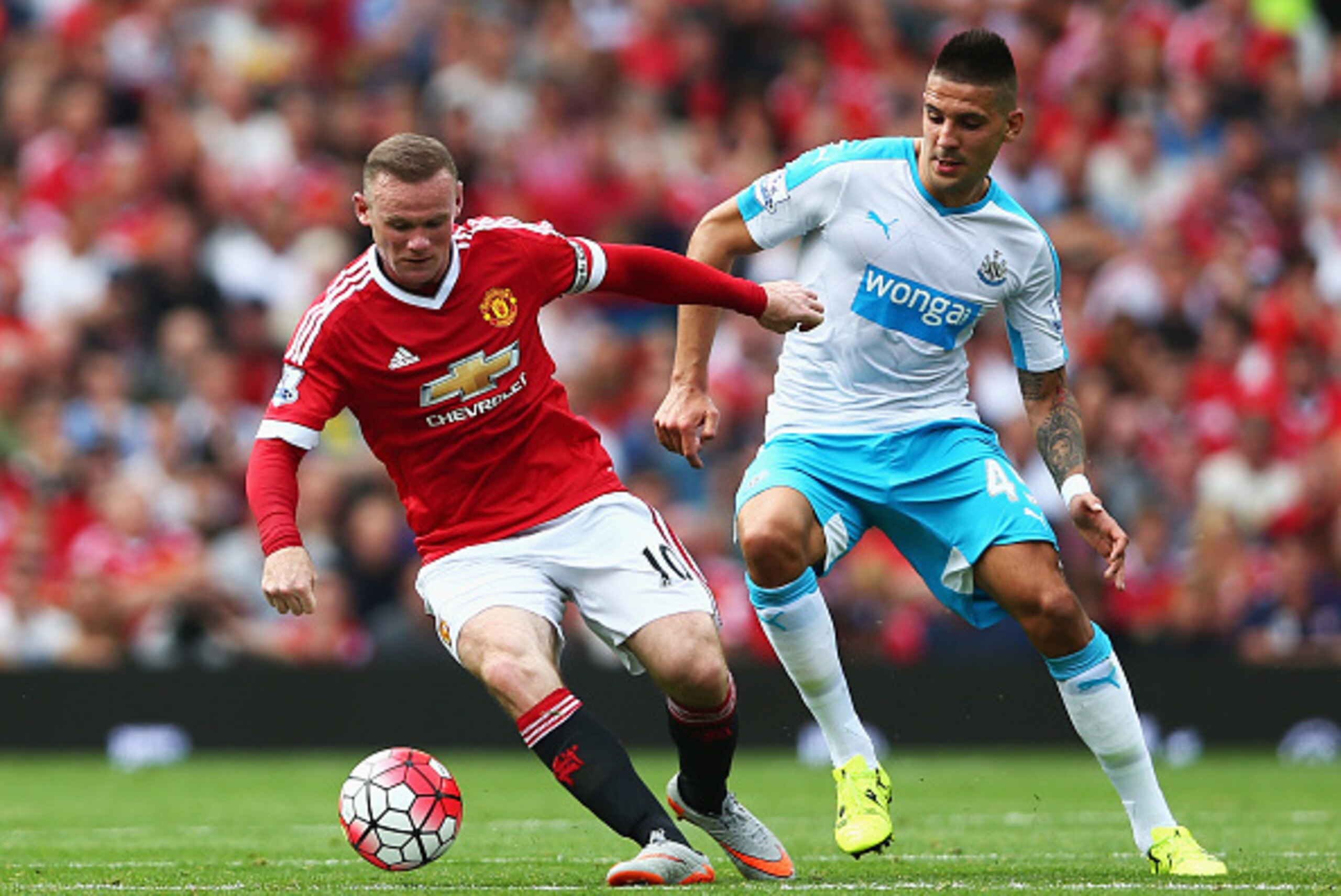 MANCHESTER, ENGLAND - AUGUST 22:  Wayne Rooney of Manchester United and Aleksandar Mitrovic of Newcastle United compete for the ball during the Barclays Premier League match between Manchester United and Newcastle United at Old Trafford on August 22, 2015