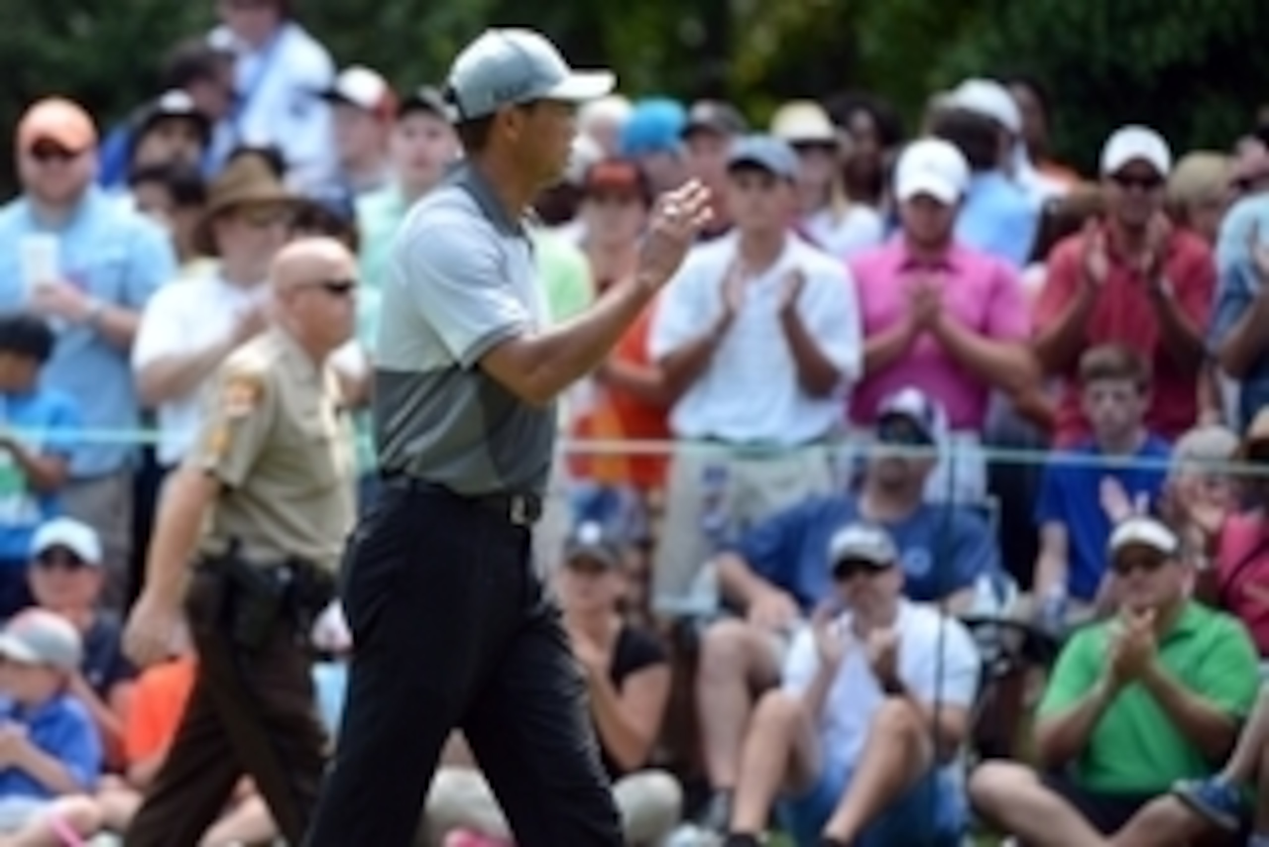 Aug 22, 2015; Greensboro, NC, USA; Tiger Woods (center) waves to the crowd on the 3rd hole during the third round of the Wyndham Championship golf tournament at Sedgefield Country Club. Mandatory Credit: Rob Kinnan-USA TODAY Sports