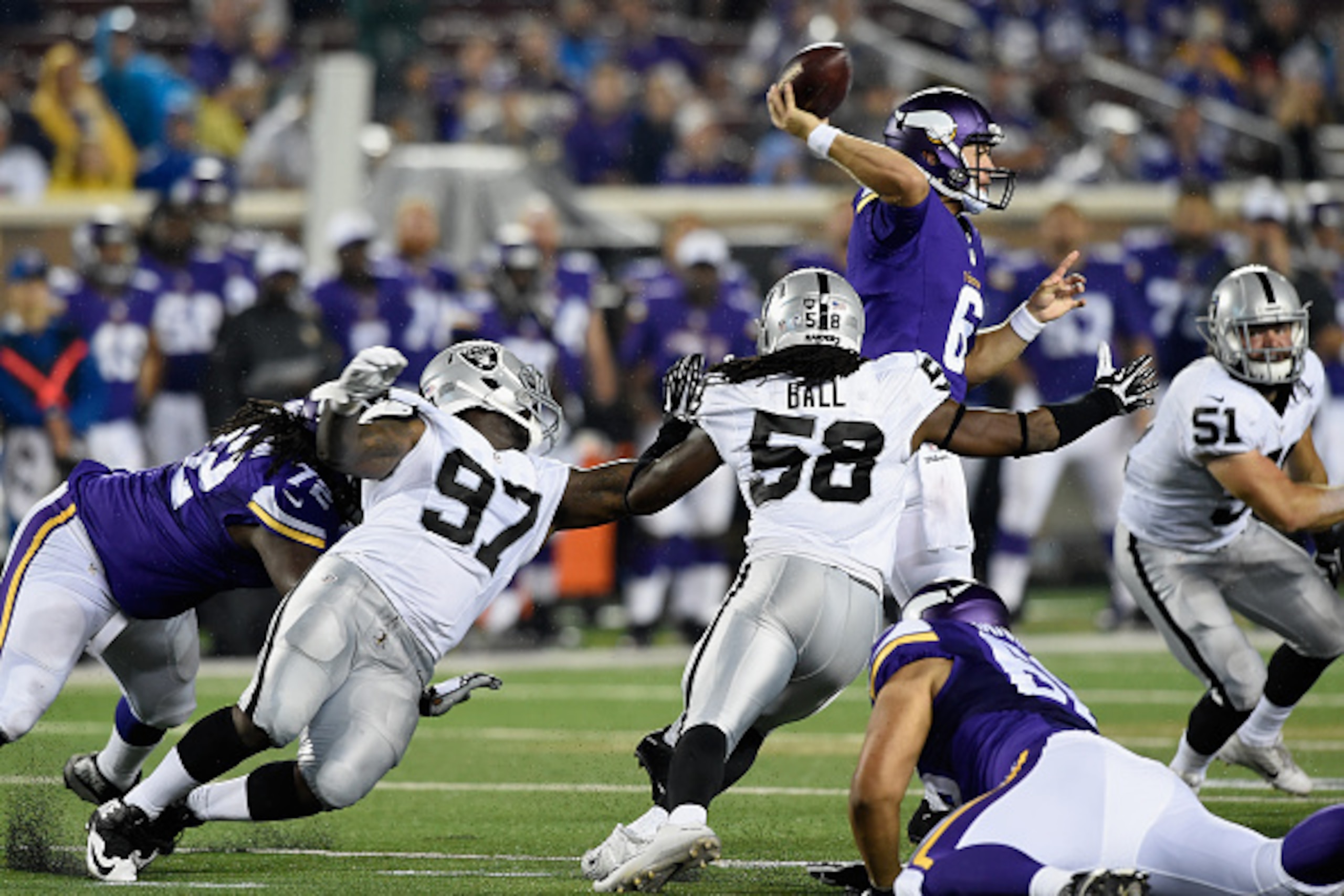 MINNEAPOLIS, MN - AUGUST 22: Taylor Heinicke #6 of the Minnesota Vikings throws the ball under pressure form Mario Jr. Edwards #97, Neiron Ball #58 and Ben Heeney #51 of the Oakland Raiders during the third quarter of the preseason game on August 22, 2015
