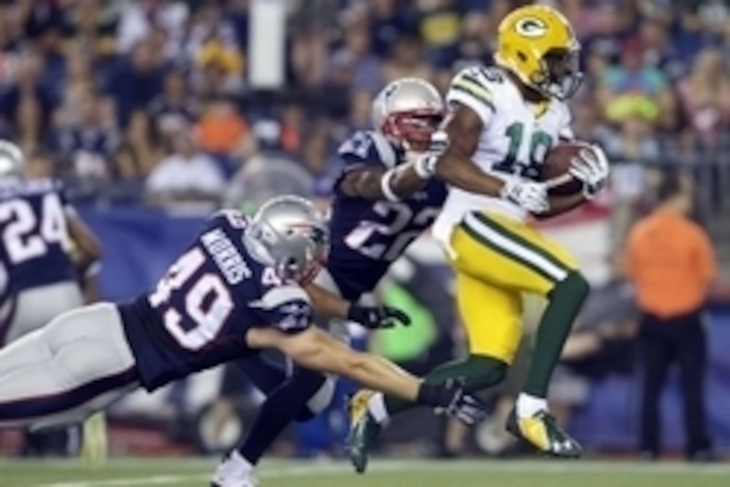 Aug 13, 2015; Foxborough, MA, USA; Green Bay Packers wide receiver Randall Cobb (18) runs the ball against New England Patriots linebacker James Morris (49) and corner back Robert McClain (22) during the first half in a preseason NFL football game at Gill