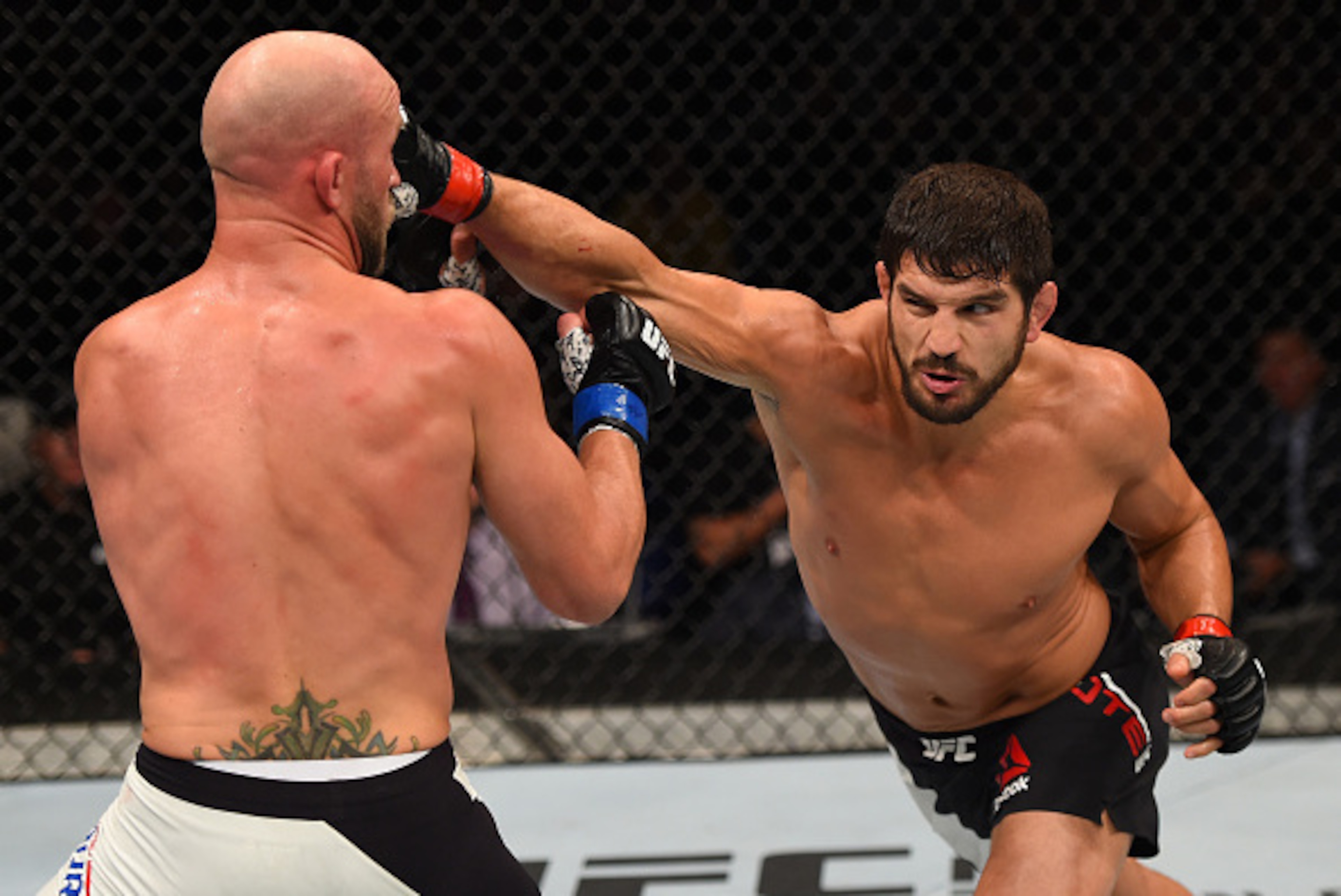 SASKATOON, SK - AUGUST 23:  (R-L) Patrick Cote punches Josh Burkman of the United States in their welterweight bout during the UFC event at the SaskTel Centre on August 23, 2015 in Saskatoon, Saskatchewan, Canada. (Photo by Jeff Bottari/Zuffa LLC/Zuffa LL