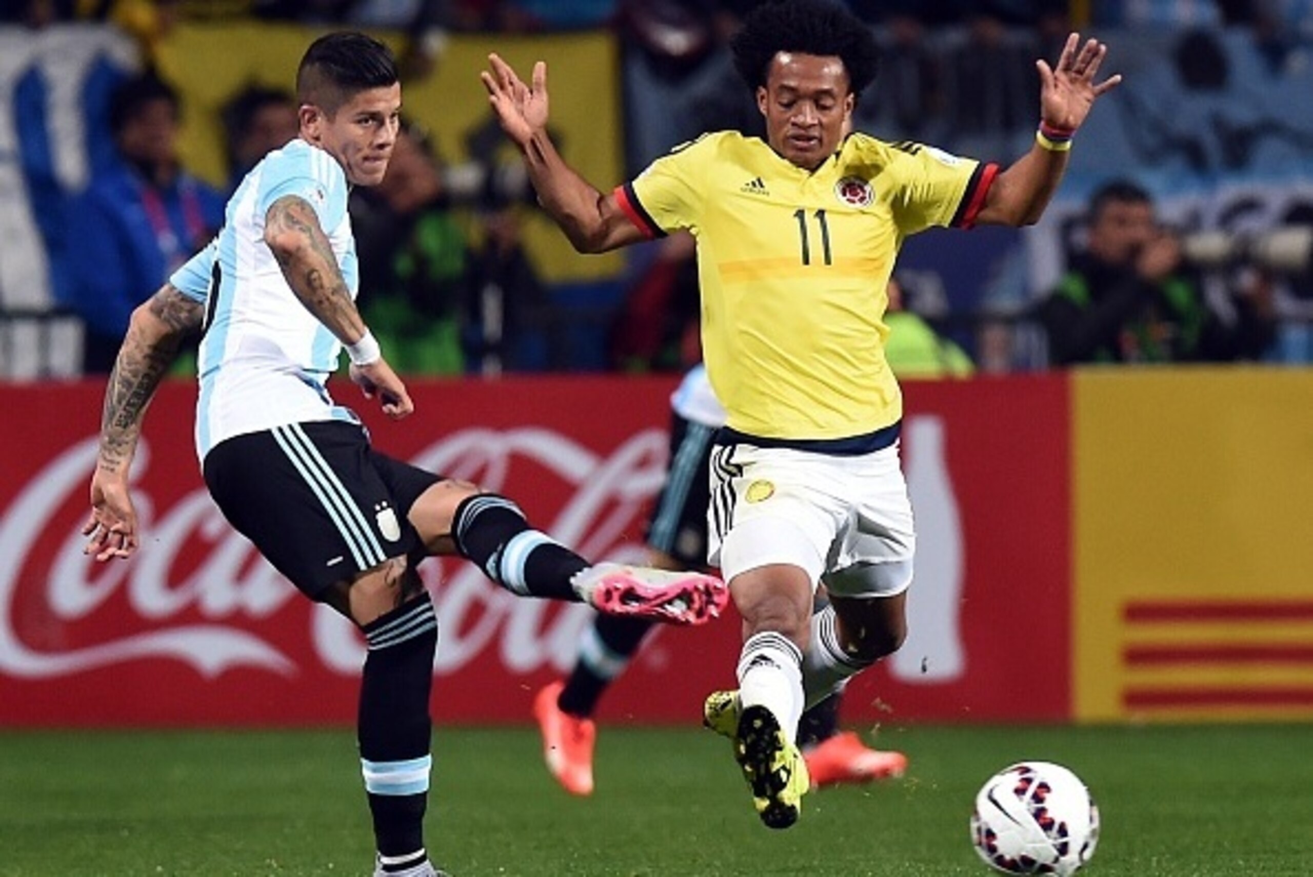 Argentina's defender Marcos Rojo (L) kicks the ball next to Colombia's midfielder Juan Cuadrado during their 2015 Copa America football championship quarter-final match, in Viña del Mar, Chile, on June 26, 2015.   AFP PHOTO / PABLO PORCIUNCULA        (Pho