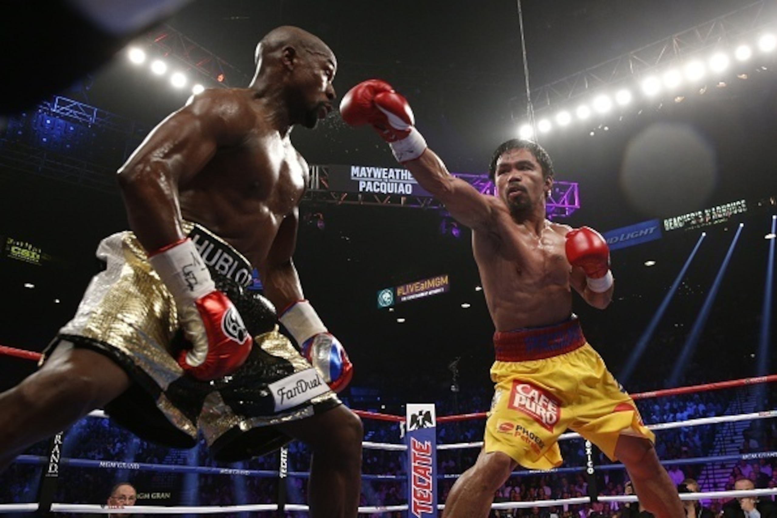 Floyd Mayweather Jr. exchange punches with Manny Pacquiao during their welterweight unification championship bout, May 2, 2015 at MGM Grand Garden Arena in Las Vegas, Nevada.  Mayweather defeated Pacquiao by unanimous decision.  AFP PHOTO / JOHN GURZINKSI