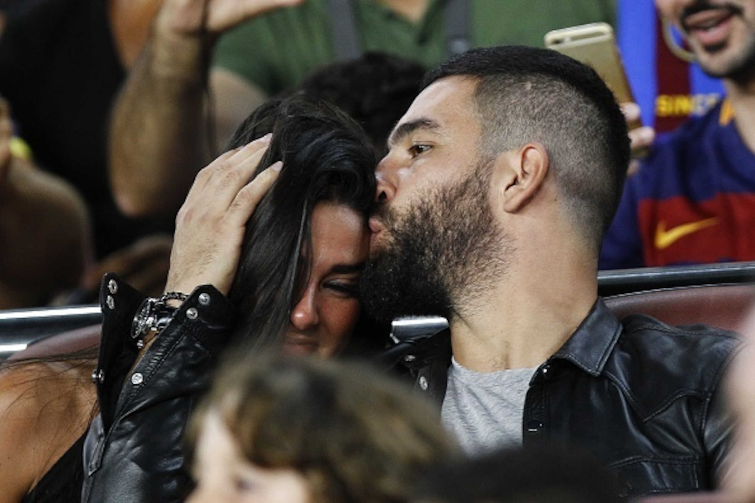 Barcelona's Turkish midfielder Arda Turan (R) kisses a girl as they sit on the grandstands during the Spanish Supercup second-leg football match FC Barcelona vs Athletic Club Bilbao at the Camp Nou stadium in Barcelona on August 17, 2015. AFP PHOTO / QUIQ