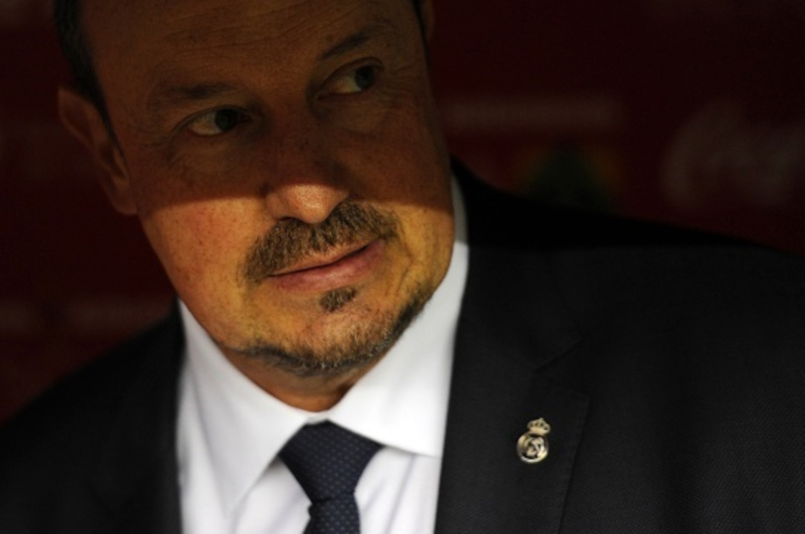 Real Madrid's coach Rafael Benitez is pictured on the bench before the start of the Spanish league football match Sporting Gijon vs Real Madrid CF at the El Molinon stadium in Gijon on August 23, 2015. The match finished with a 0-0 draw.   AFP PHOTO/ MIGU
