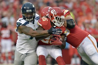 Aug 21, 2015; Kansas City, MO, USA; Kansas City Chiefs running back Jamaal Charles (25) is tackled by Seattle Seahawks defensive end Michael Bennett (72) during the first half at Arrowhead Stadium. Mandatory Credit: Denny Medley-USA TODAY Sports