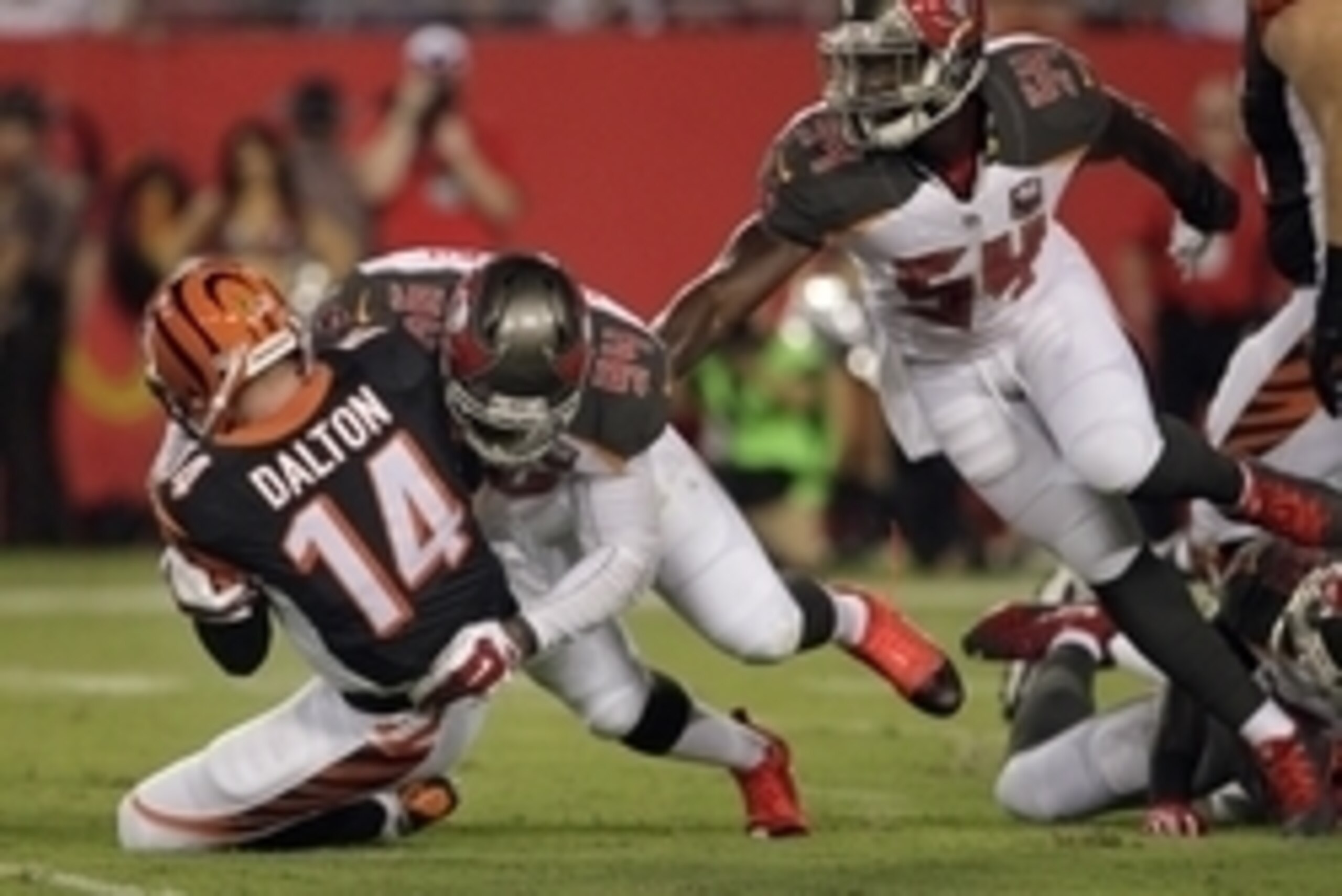 Aug 24, 2015; Tampa, FL, USA; Cincinnati Bengals quarterback Andy Dalton (14) is sacked by Tampa Bay Buccaneers defensive end George Johnson (94) during the first quarter of a preseason NFL football game at Raymond James Stadium. Mandatory Credit: Reinhol