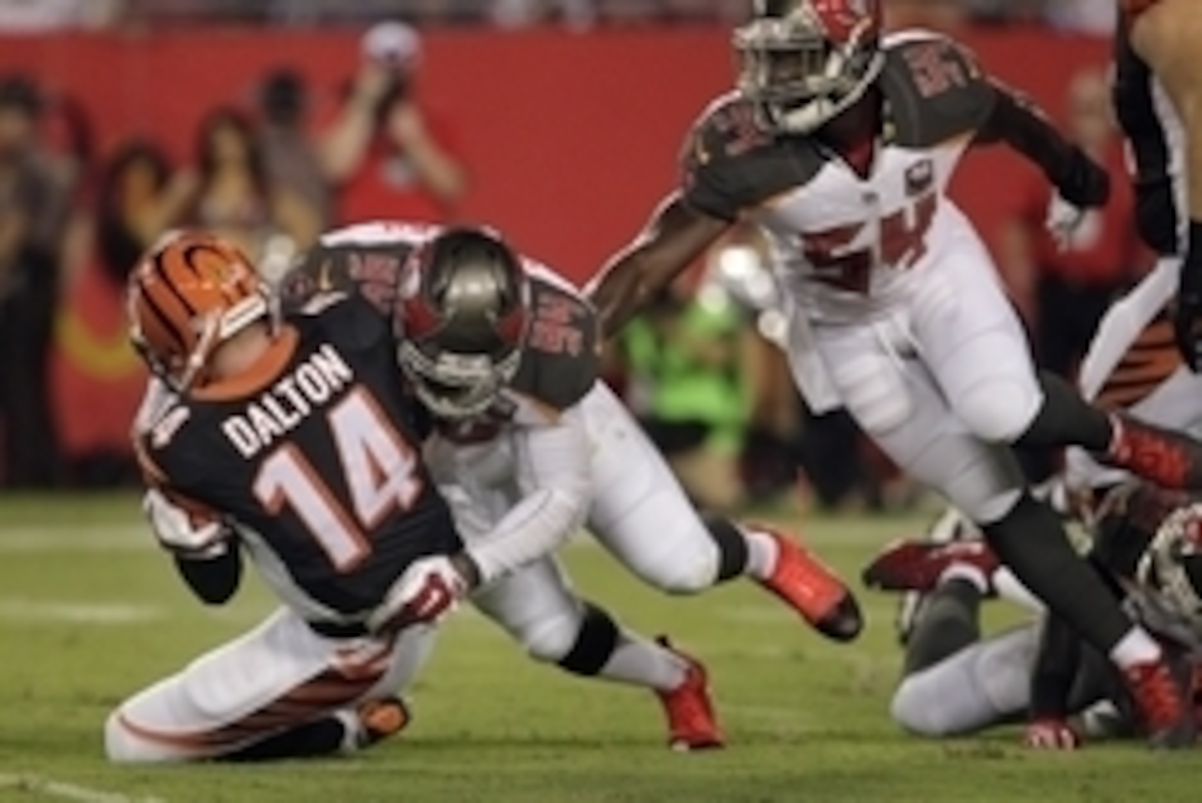 Aug 24, 2015; Tampa, FL, USA; Cincinnati Bengals quarterback Andy Dalton (14) is sacked by Tampa Bay Buccaneers defensive end George Johnson (94) during the first quarter of a preseason NFL football game at Raymond James Stadium. Mandatory Credit: Reinhol