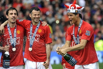 Manchester United's Portuguese midfielder Cristiano Ronaldo (R) celebrates with English defender Gary Neville (L) and Welsh midfielder Ryan Giggs after they clinch the title with a 0-0 draw against Arsenal in the English Premier League football match at O Manchester United's Portuguese midfielder Cristiano Ronaldo (R) celebrates with English defender Gary Neville (L) and Welsh midfielder Ryan Giggs after they clinch the title with a 0-0 draw against Arsenal in the English Premier League football match at O