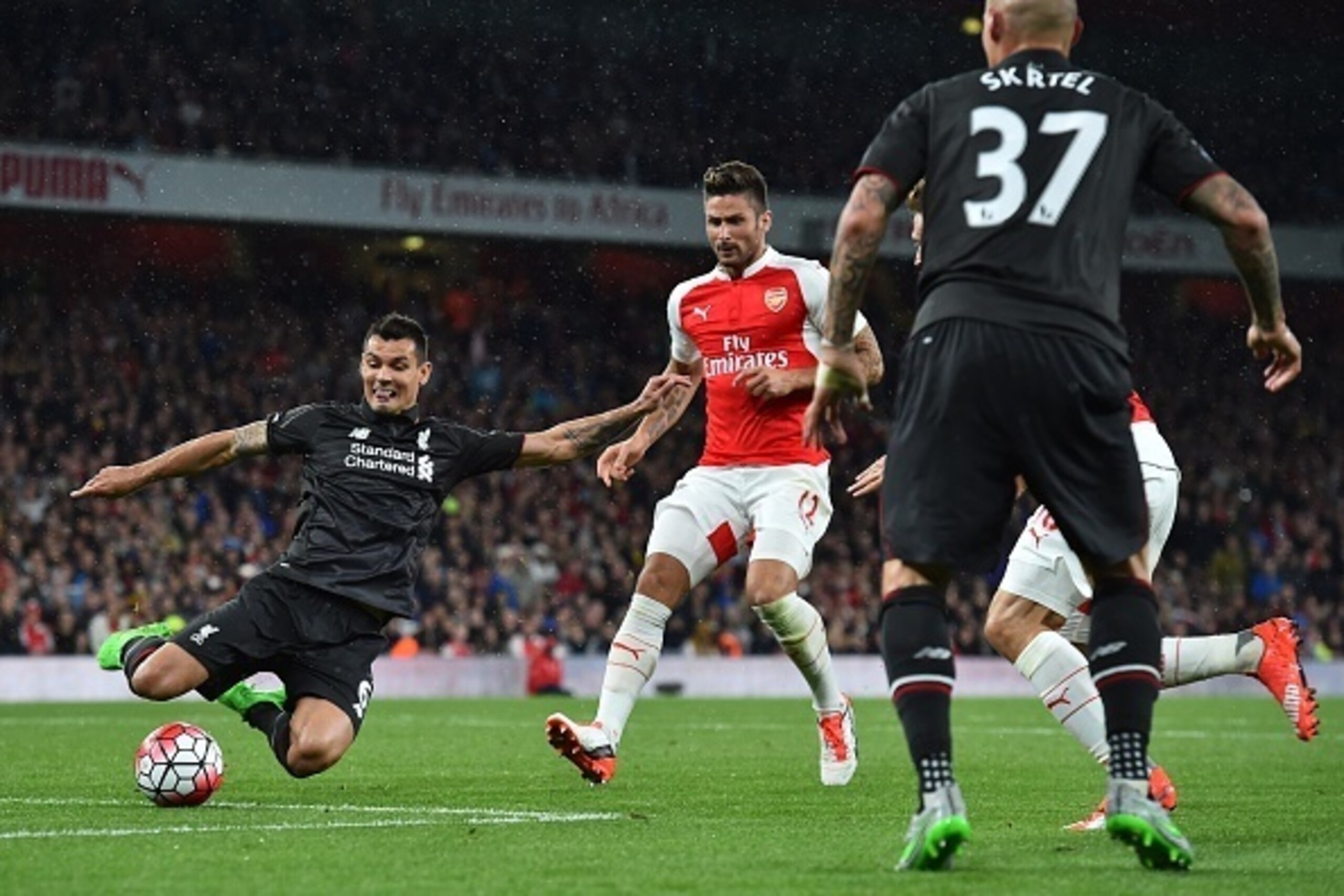 Liverpool's Croatian defender Dejan Lovren (L) blocks a shot by Arsenal's French striker Olivier Giroud (C) during the English Premier League football match between Arsenal and Liverpool at the Emirates stadium, north London on August 24, 2015. AFP PHOTO 