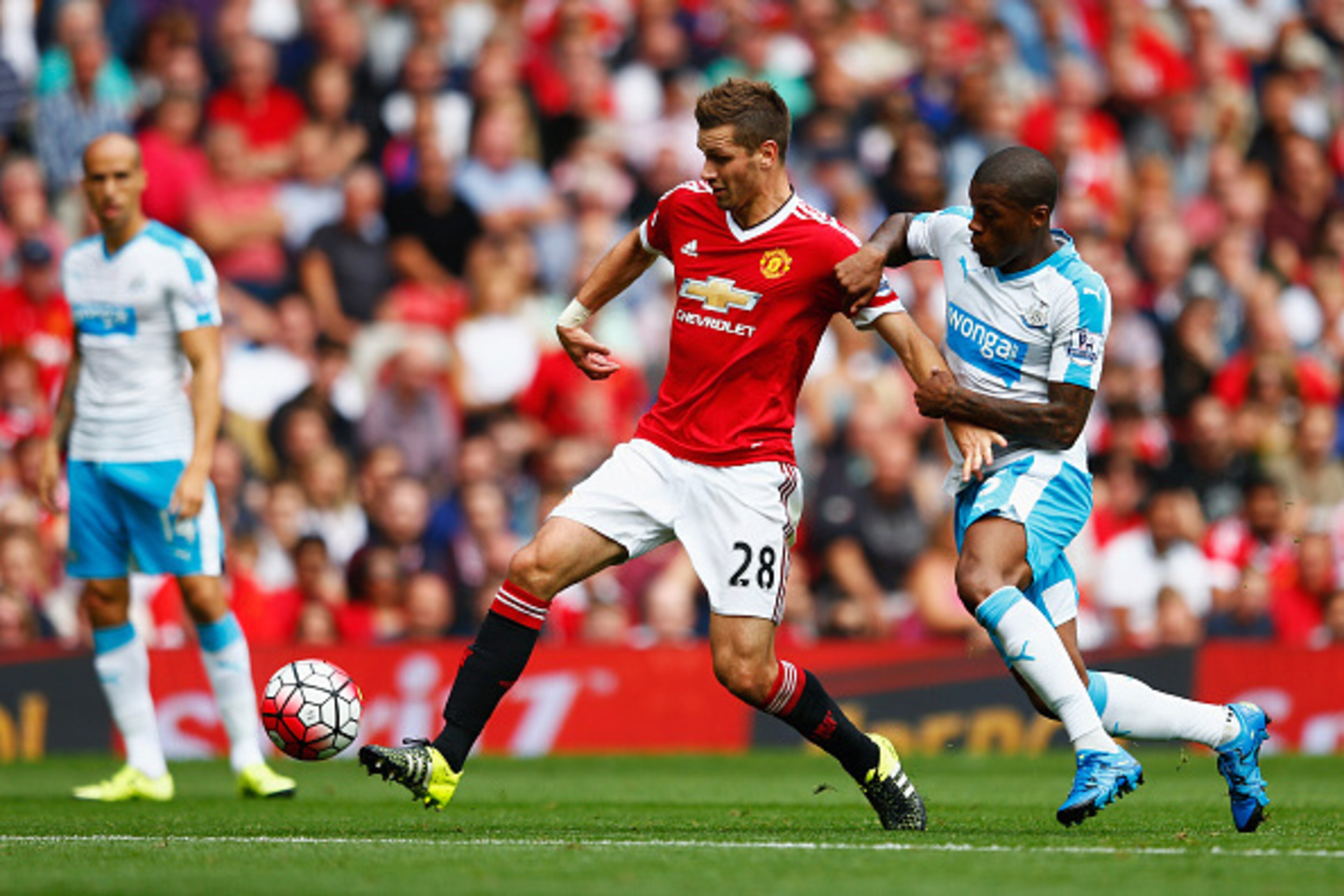 MANCHESTER, ENGLAND - AUGUST 22: Morgan Schneiderlin of Manchester United and Georginio Wijnaldum of Newcastle United compete for the ball during the Barclays Premier League match between Manchester United and Newcastle United at Old Trafford on August 22