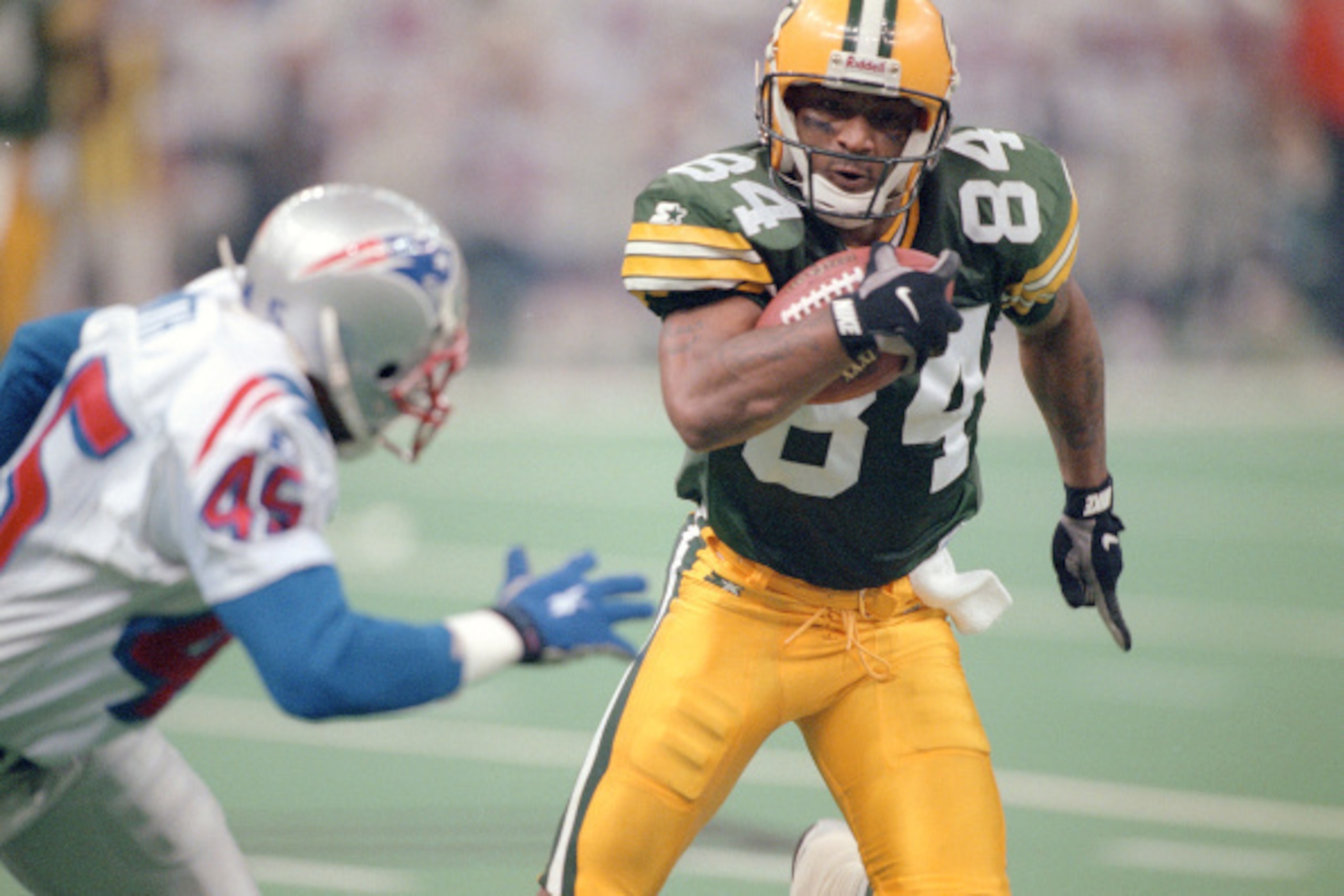 NEW ORLEANS, LA - JANUARY 26:  Andre Rison #84 of the Green Bay Packers runs with the ball while pursued by Otis Smith #45 of the New England Patriots during Super Bowl XXXI January 26, 1997 at the Louisiana Superdome in New Orleans, Louisiana . The Packe