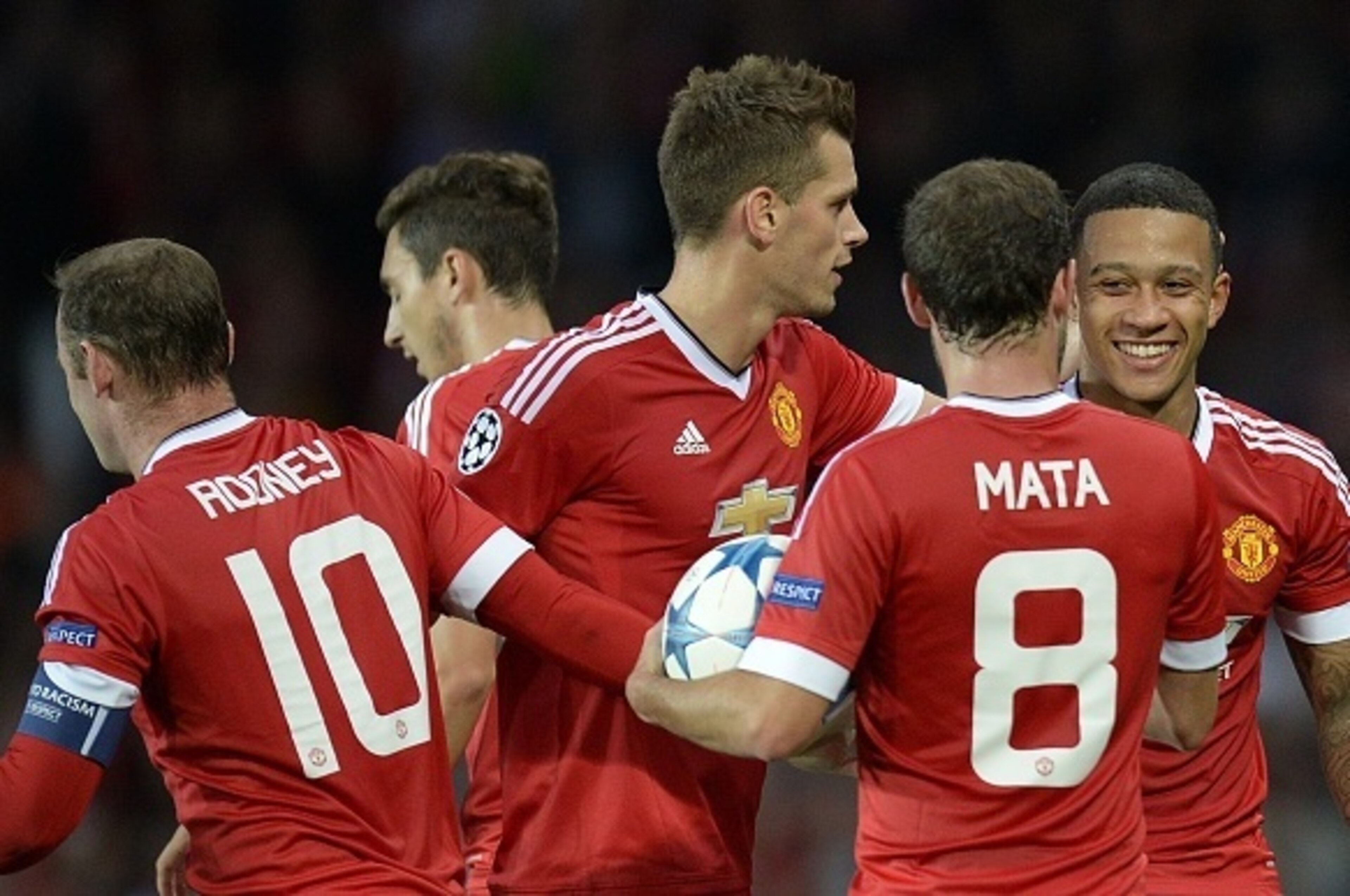 Manchester United's Dutch midfielder Memphis Depay (R) is congratulated after scoring his team's second goal during the UEFA Champions League play off football match between Manchester United and Club Brugge at Old Trafford in Manchester, north west Engla