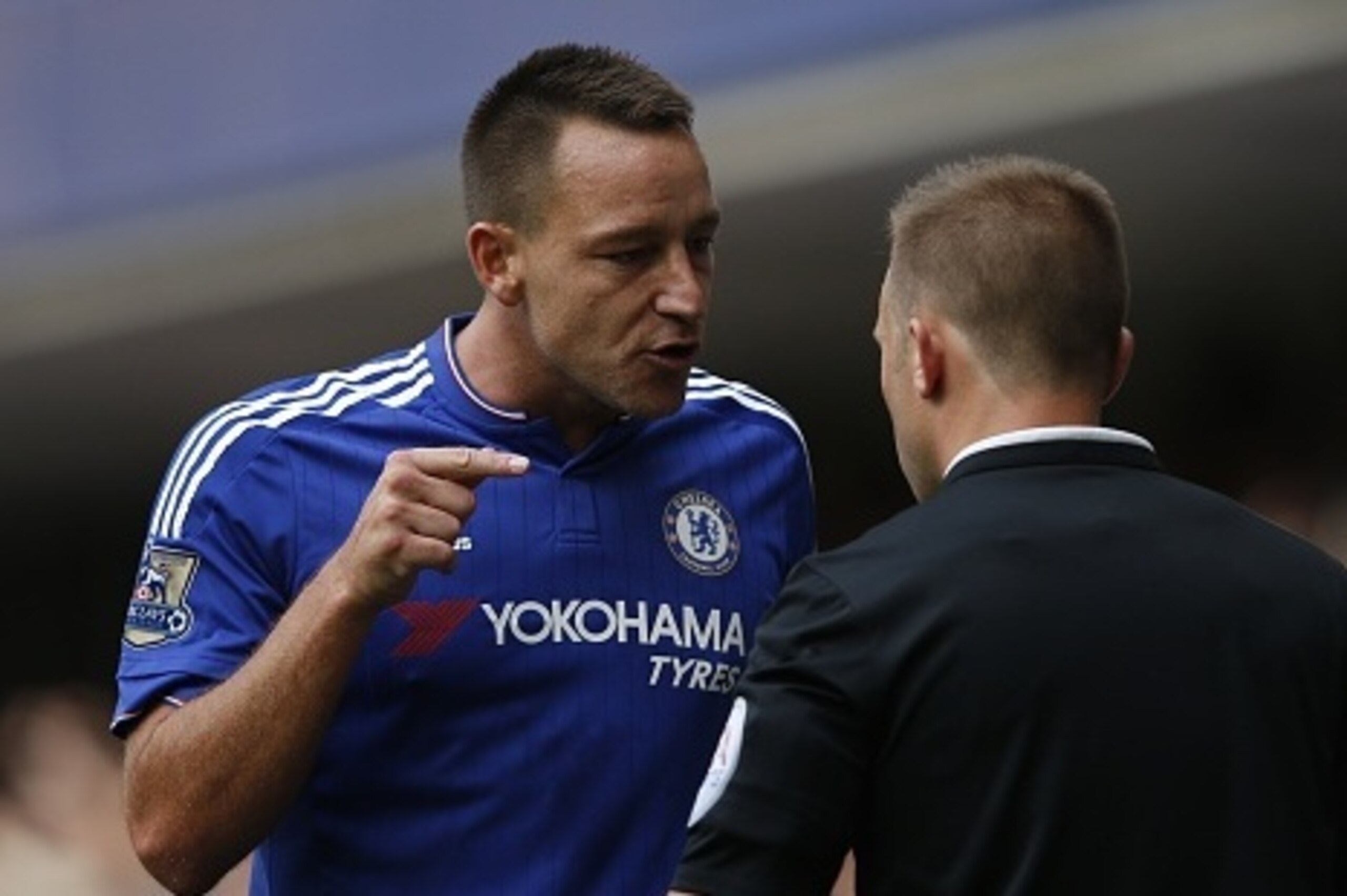 Chelsea's English defender John Terry (L) talks with assistant referee Harry Lennard (R) after Chelsea's Belgian goalkeeper Thibaut Courtois was sent off and a penalty conceeded during the English Premier League football match between Chelsea and Swansea 