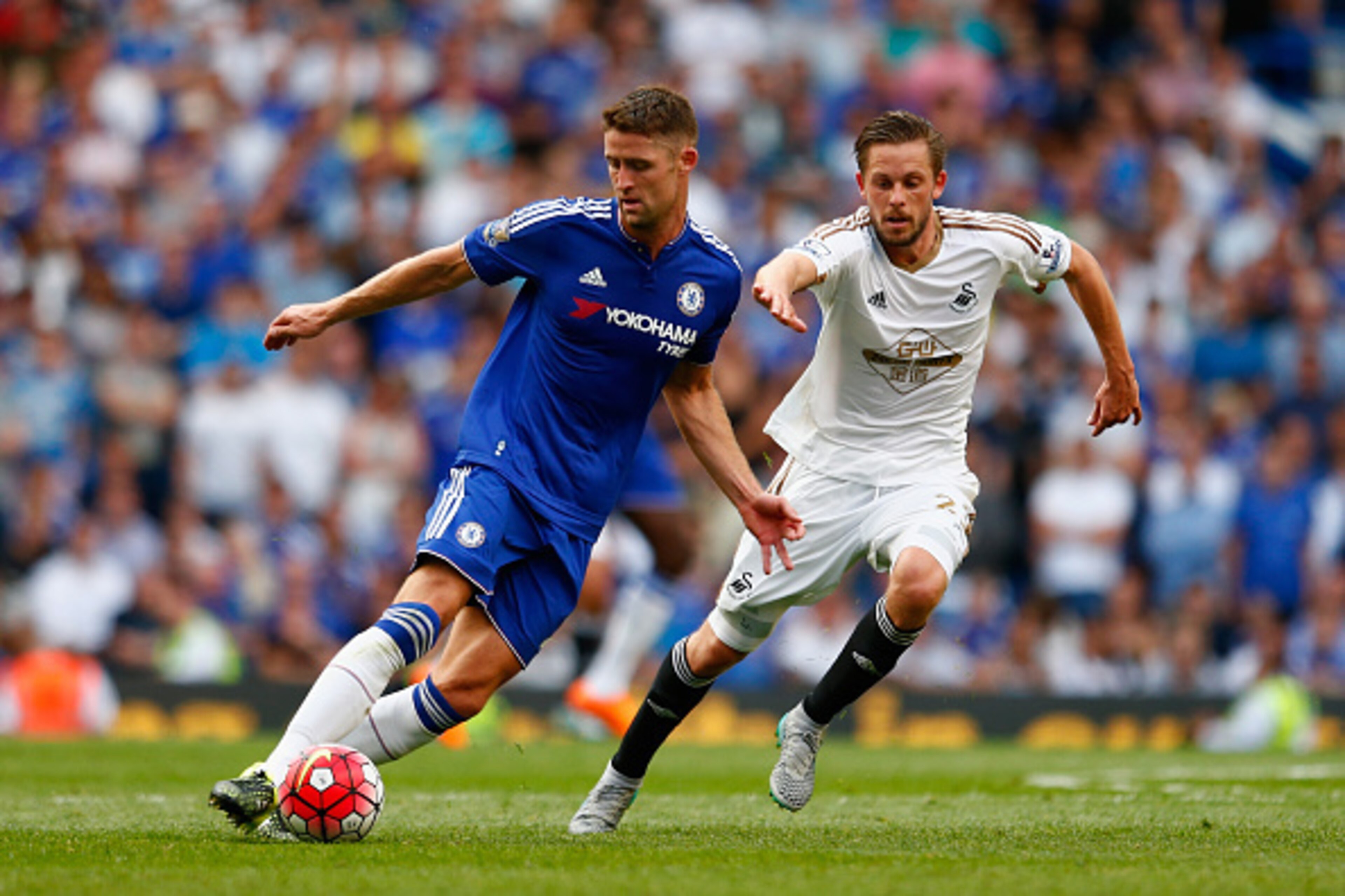 LONDON, ENGLAND - AUGUST 08: Gary Cahill of Chelsea and Gylfi Sigurdsson of Swansea City compete for the ball during the Barclays Premier League match between Chelsea and Swansea City at Stamford Bridge on August 8, 2015 in London, England.  (Photo by Jul
