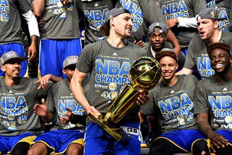 CLEVELAND, OH - JUNE 16: Klay Thompson #11 of the Golden State Warriors holds the Larry O'Brien Trophy after a victory over the Cleveland Cavaliers in Game Six to win the 2015 NBA Finals at The Quicken Loans Arena on June 16, 2015 in Cleveland, Ohio. NOTE