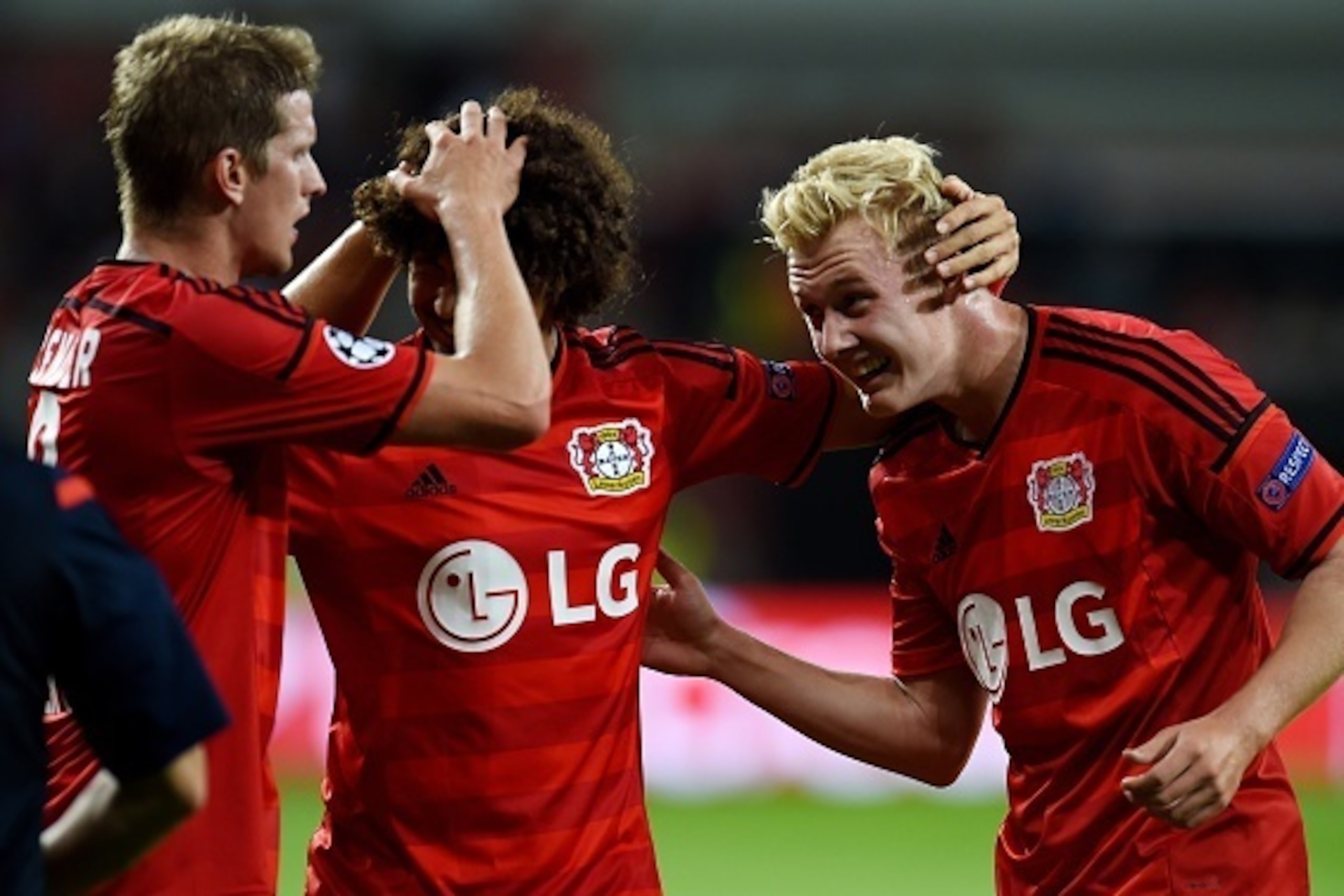 Leverkusen's players celebrate after the UEFA Champions League second leg playoff football match between Bayer Leverkusen and SS Lazio in Leverkusen, western Germany, on August 26, 2015.  Leverkusen wins 3-0. AFP PHOTO / PATRIK STOLLARZ        (Photo cred