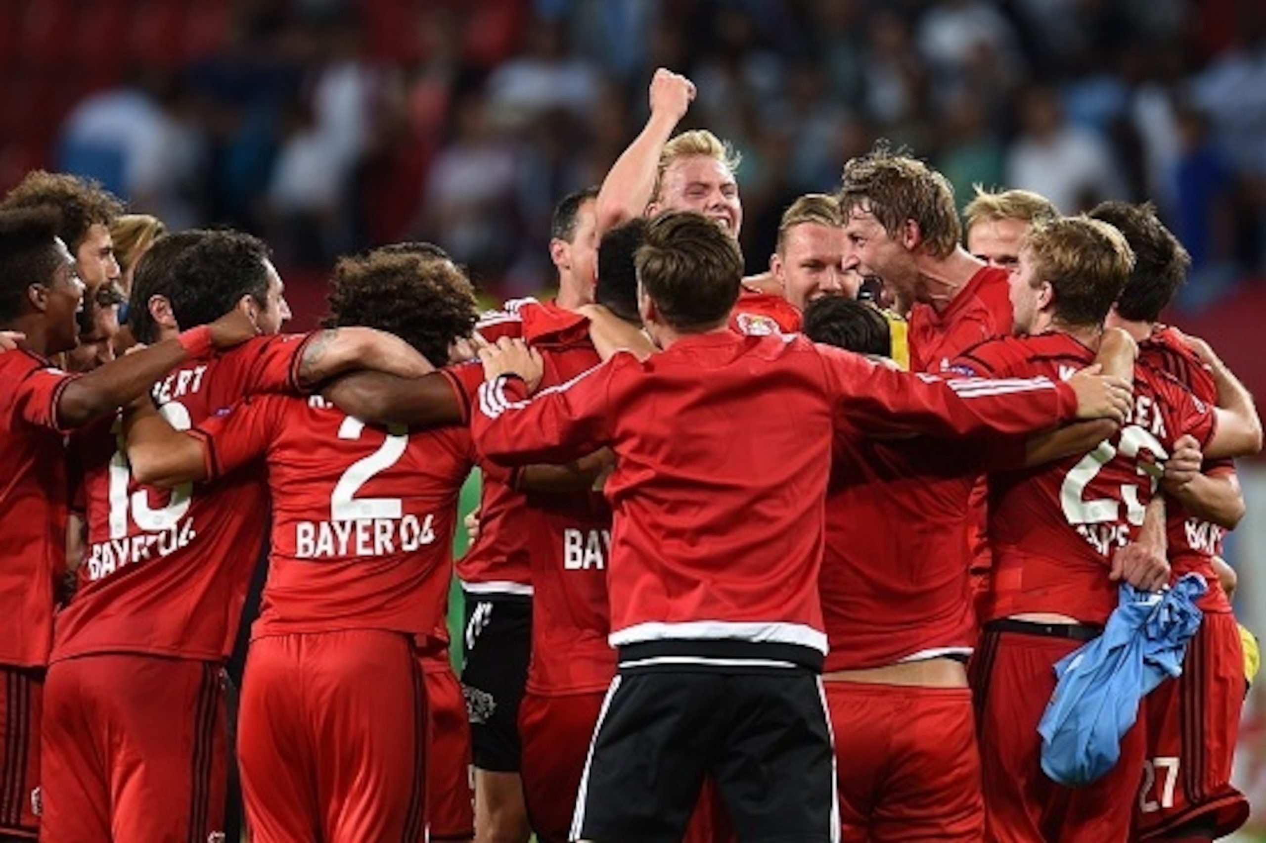 Leverkusen's players celebrate after the UEFA Champions League second leg playoff football match between Bayer Leverkusen and SS Lazio in Leverkusen, western Germany, on August 26, 2015.  Leverkusen wins 3-0. AFP PHOTO / PATRIK STOLLARZ        (Photo cred