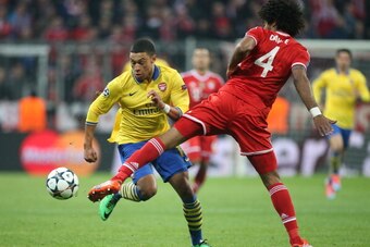 MUNICH, GERMANY - MARCH 11: Alex Oxlade-Chamberlain of Arsenal and Dante of Bayern Muenchen in action during the UEFA Champions League Round of 16 match between FC Bayern Muenchen and Arsenal FC on March 11, 2014 in Munich, Bavaria, Germany. (Photo by Jea