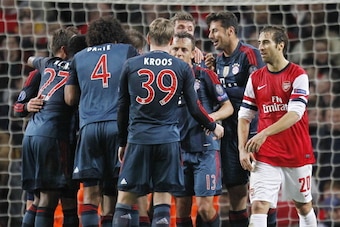 Arsenal's French midfielder Mathieu Flamini (R) walks past Bayern Munich players as they celebrate Thomas Muller's goal during the UEFA Champions League Last 16, first leg football match between Arsenal and Bayern Munich at The Emirates Stadium in north L