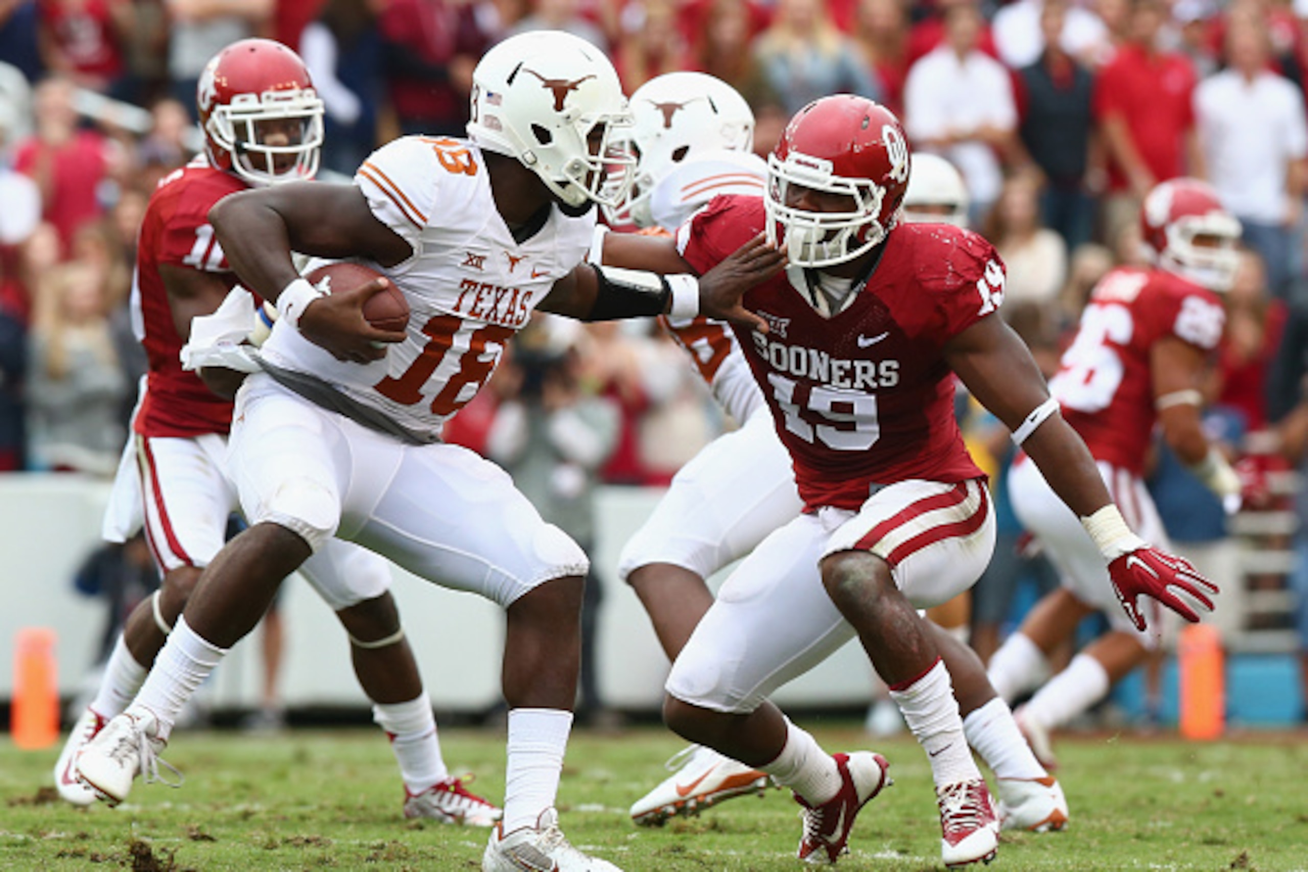DALLAS, TX - OCTOBER 11:  Tyrone Swoopes #18 of the Texas Longhorns runs the ball against Eric Striker #19 of the Oklahoma Sooners at Cotton Bowl on October 11, 2014 in Dallas, Texas.  (Photo by Ronald Martinez/Getty Images)