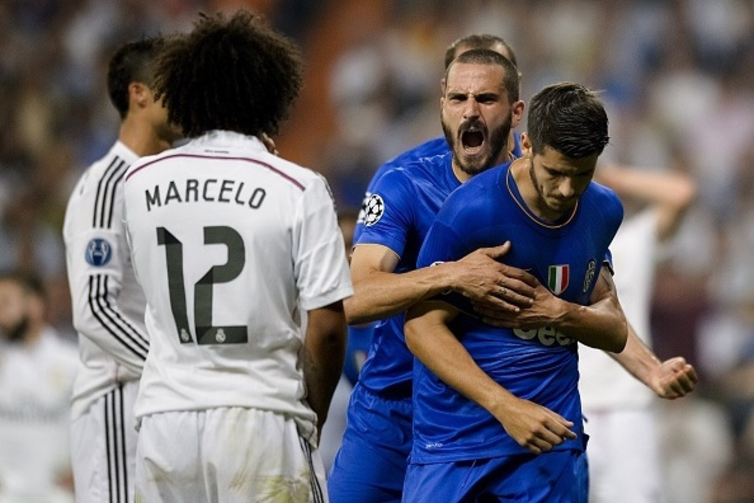 Real Madrid's Brazilian defender Marcelo (L) watches Juventus' Spanish forward Alvaro Morata (R) celebrate after scoring during the UEFA Champions League semifinal second leg football match Real Madrid FC vs Juventus at the Santiago Bernabeu stadium in Ma