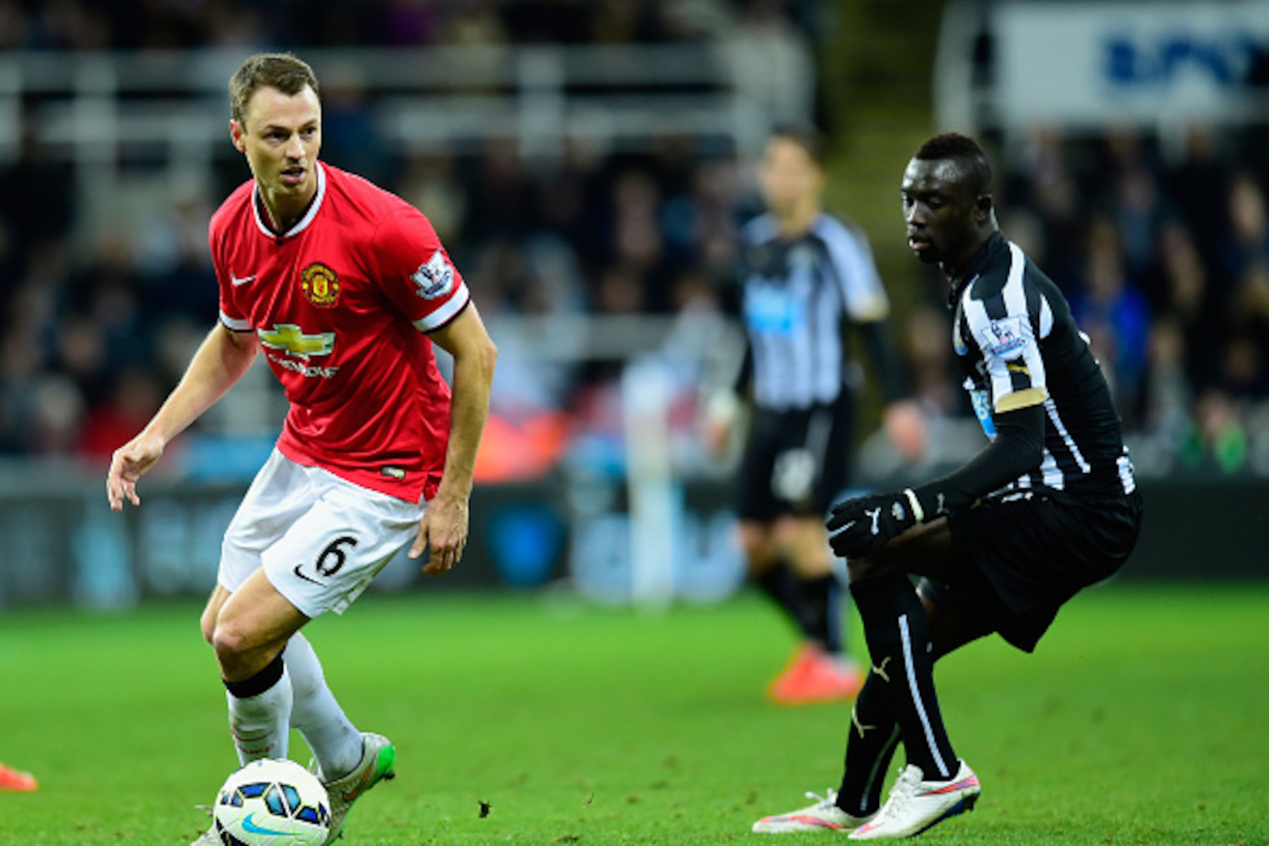NEWCASTLE UPON TYNE, ENGLAND - MARCH 04:  Manchester United player Jonny Evans (l) in action as Papiss Cisse of Newcastle looks on during the Barclays Premier League match between Newcastle United and Manchester United at St James' Park on March 4, 2015 i