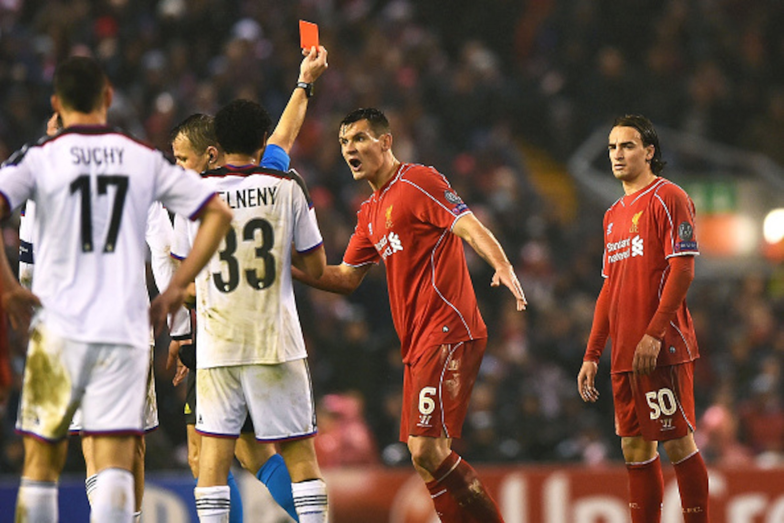 LIVERPOOL, ENGLAND - DECEMBER 09:  Dejan Lovren #6 of Liverpool reacts as teammate Lazar Markovic #50 of Liverpool is shown the red card card during the UEFA Champions League group B match between Liverpool and FC Basel 1893 at Anfield on December 9, 2014