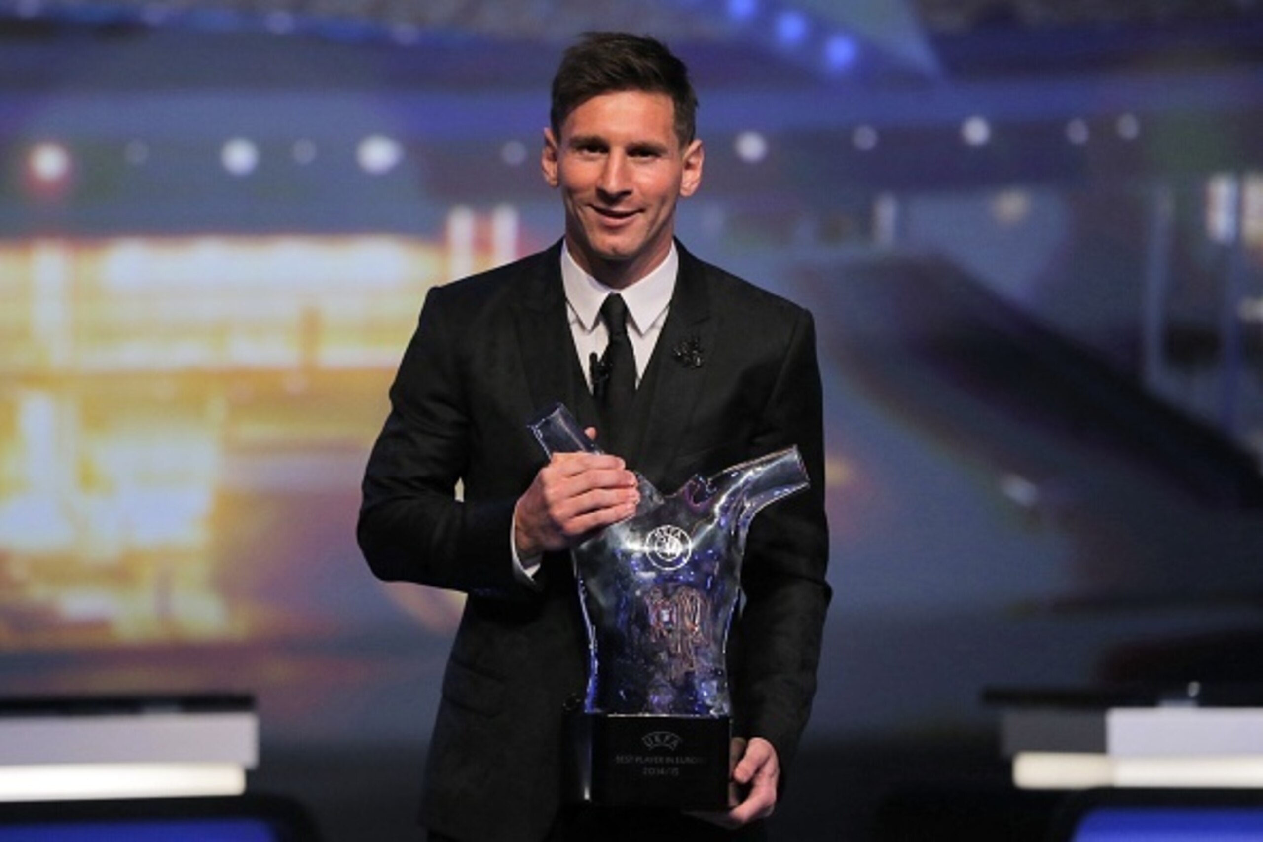 FC Barcelone Argentinian striker Lionel Messi poses with the trophy of Best Men's player in Europe at the end of the UEFA Champions League Group stage draw ceremony, on August 27, 2015 in Monaco. AFP PHOTO / VALERY HACHE        (Photo credit should read V