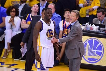 Golden State Warriors coach Steve Kerr gestures to keep Draymond Green from confronting the referee following a call against the Cleveland Cavaliers during Game 5 of the 2015 NBA Finals on June 14, 2015 at the Oracle Arena in Oakland, California. The Warr