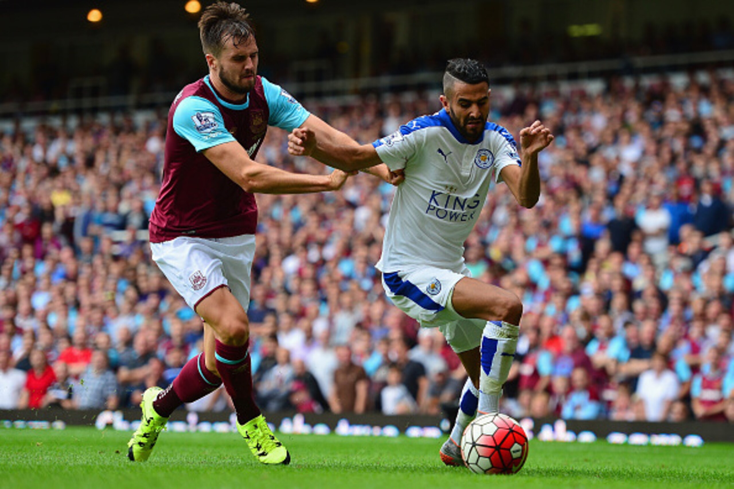LONDON, ENGLAND - AUGUST 15:  Riyad Mahrez of Leicester City and Carl Jenkinson of West Ham United compete for the ball during the Barclays Premier League match between West Ham United and Leicester City at the Boleyn Ground on August 15, 2015 in London, 