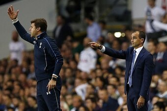 Everton's Spanish manager Roberto Martinez (R) and Tottenham Hotspur's Argentinian Head Coach Mauricio Pochettino instruct their teams during the English Premier League football match between Tottenham Hotspur and Everton at White Hart Lane in north Londo