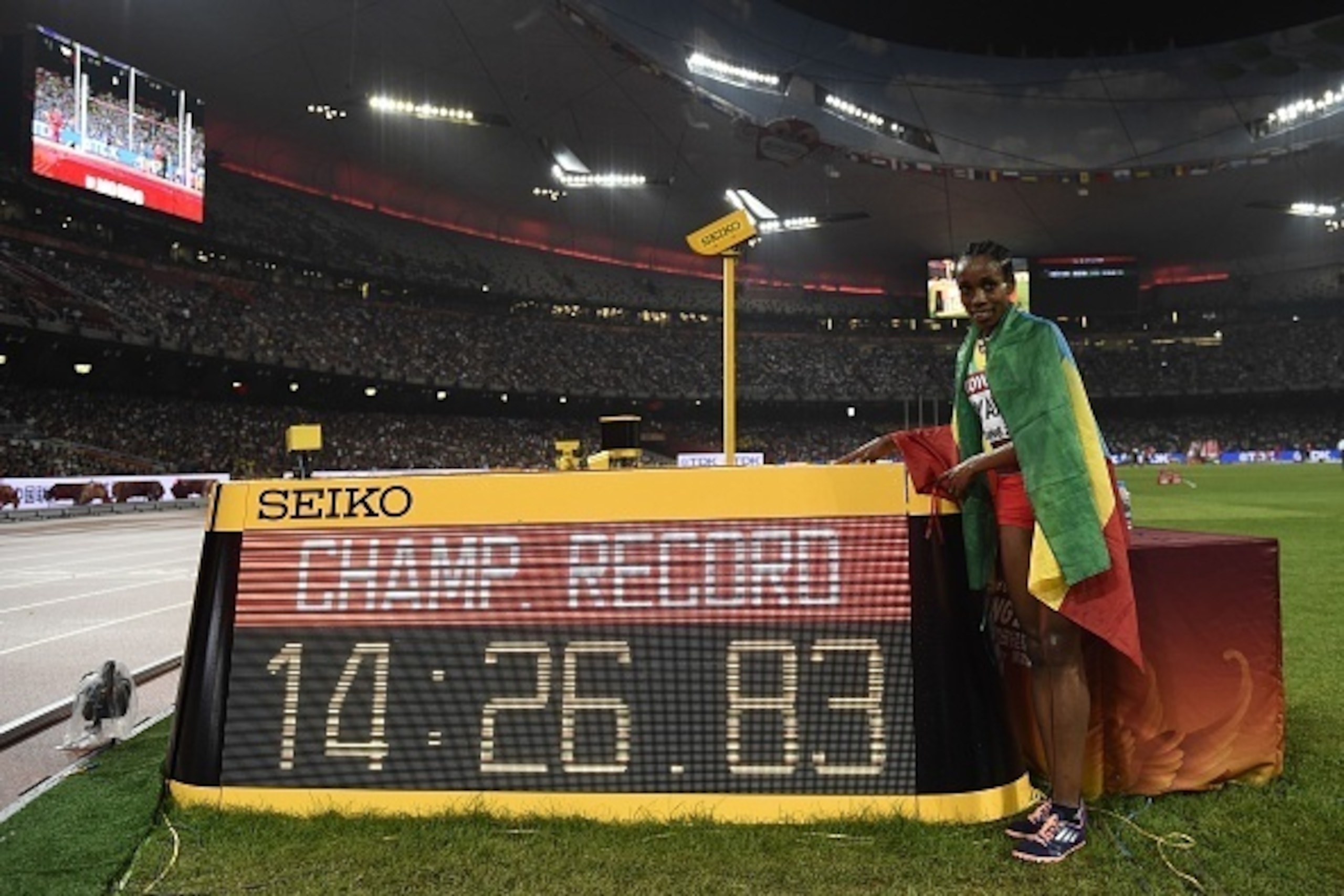 Ethiopia's Almaz Ayana celebrates setting a championship record after winning the final of the women's 5000 metres athletics event at the 2015 IAAF World Championships at the 'Bird's Nest' National Stadium in Beijing on August 30, 2015.  AFP PHOTO / FRANC