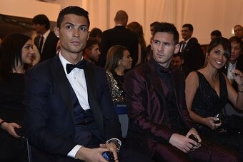 Real Madrid and Portugal forward Cristiano Ronaldo (L) sits next to Barcelona and Argentina forward Lionel Messi and his wife Argentinian model Antonella Roccuzzo as they wait for the start of the 2014 FIFA Ballon d'Or award ceremony at the Kongresshaus i