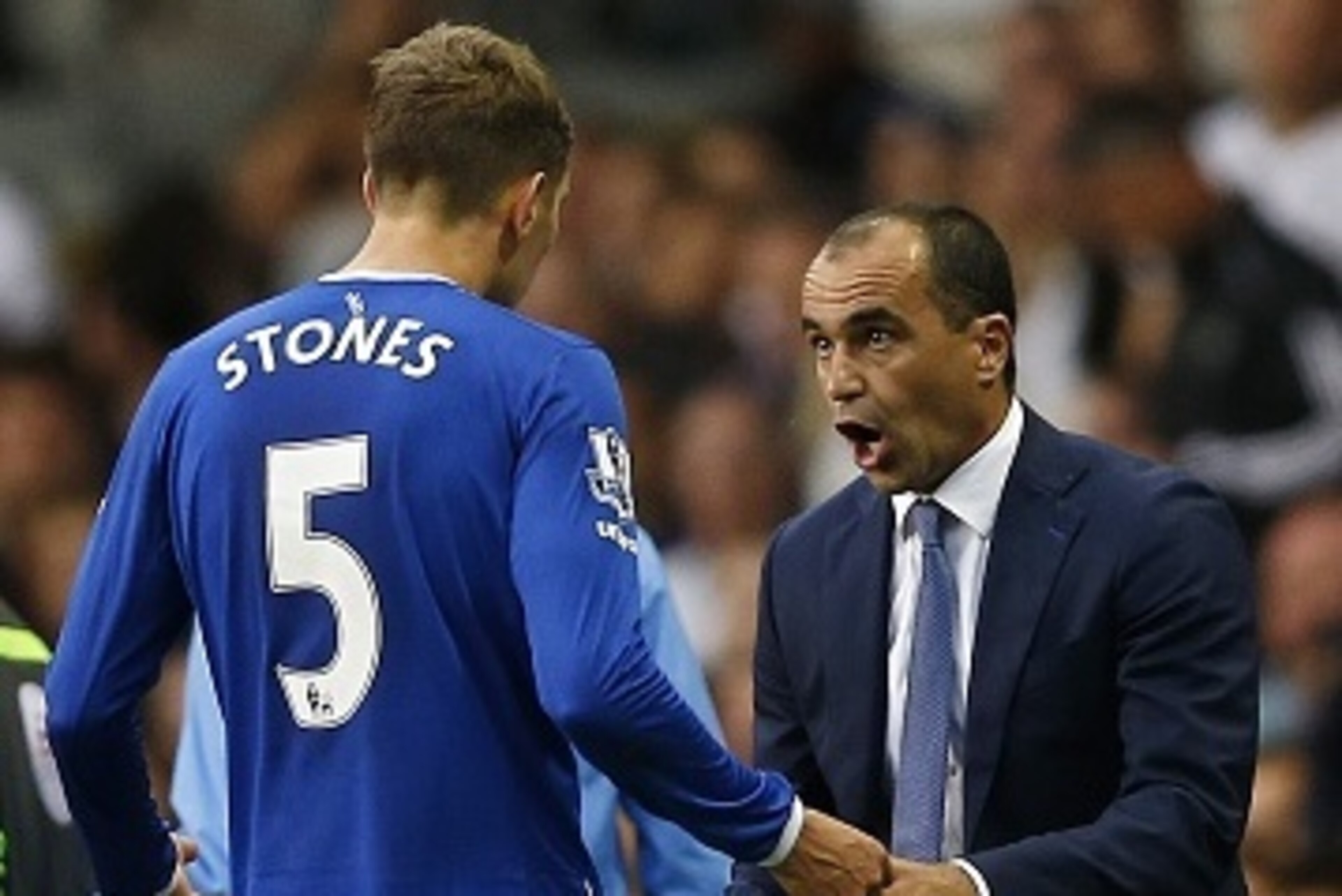 Everton's Spanish manager Roberto Martinez (R) speaks with Everton's English defender John Stones during the English Premier League football match between Tottenham Hotspur and Everton at White Hart Lane in north London on August 29, 2015. AFP PHOTO / JUS