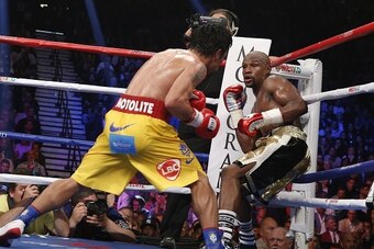 Floyd Mayweather Jr. exchange punches with Manny Pacquiao during their welterweight unification championship bout, May 2, 2015 at MGM Grand Garden Arena in Las Vegas, Nevada.  Mayweather defeated Pacquiao by unanimous decision.  AFP PHOTO / JOHN GURZINKSI