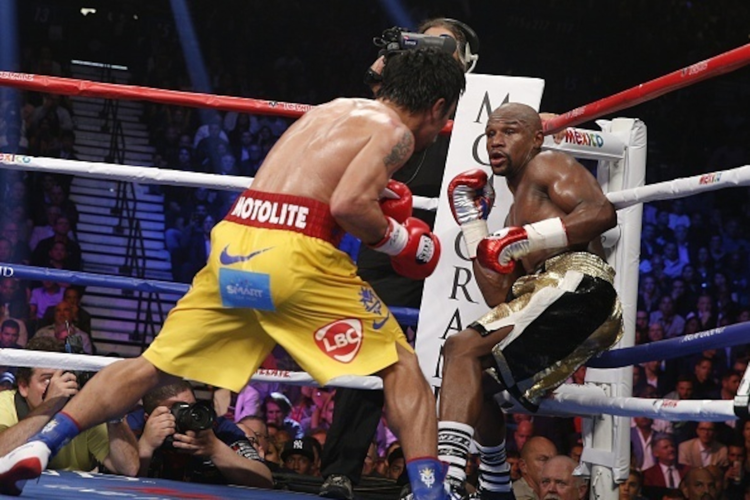 Floyd Mayweather Jr. exchange punches with Manny Pacquiao during their welterweight unification championship bout, May 2, 2015 at MGM Grand Garden Arena in Las Vegas, Nevada.  Mayweather defeated Pacquiao by unanimous decision.  AFP PHOTO / JOHN GURZINKSI