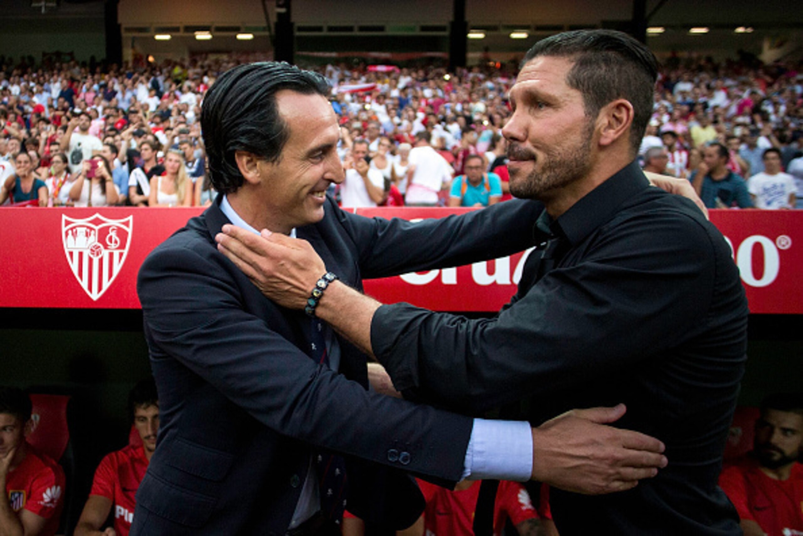 SEVILLE, SPAIN - AUGUST 30: head coach  Unai Emeri (L) of Sevilla FC embraces head coach Diego Pablo Simeone (R) of Atletico de Madrid prior to start the La Liga match between Sevilla FC and Club Atletico de Madrid at Estadio Ramon Sanchez Pizjuan on Augu