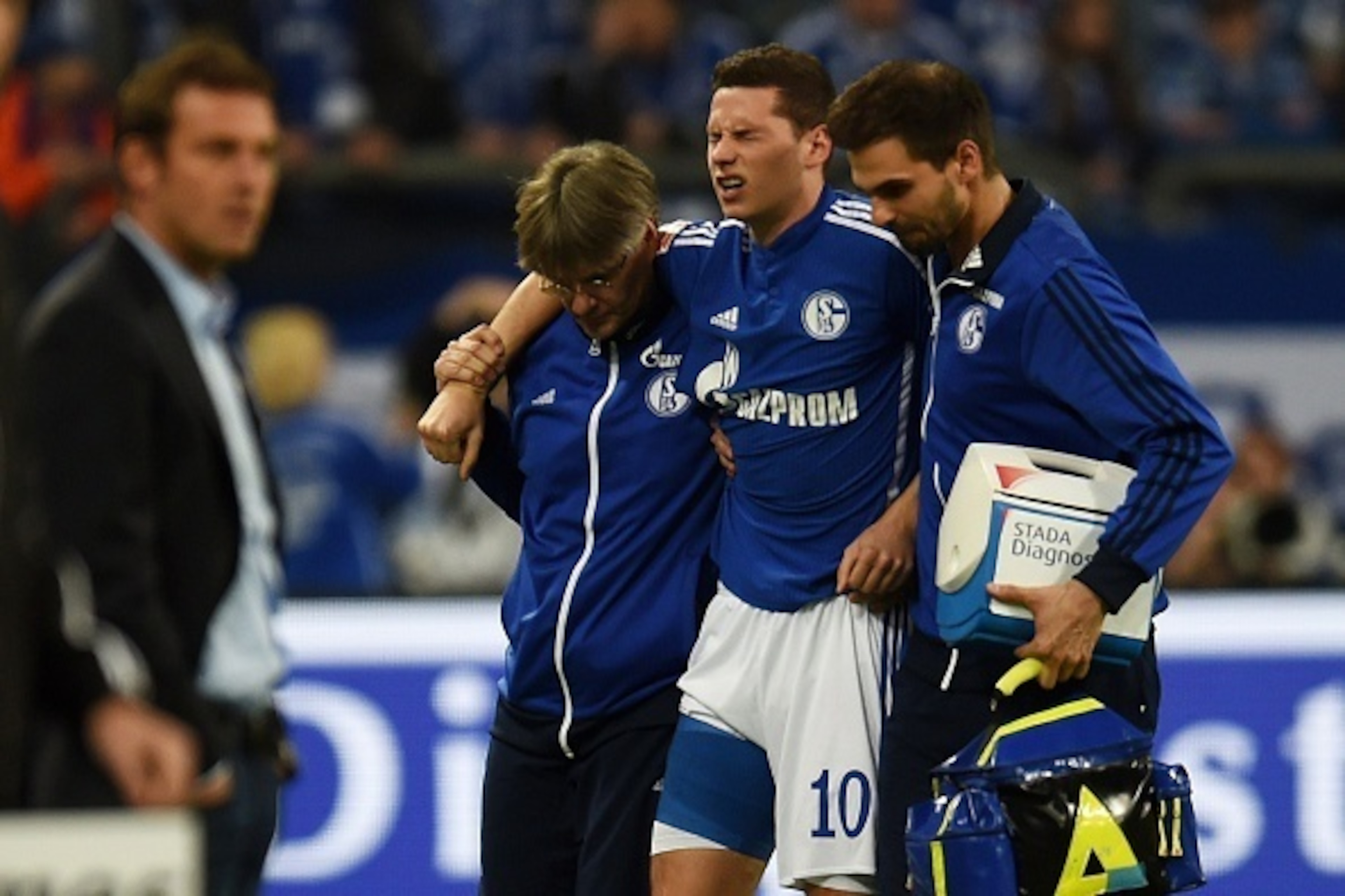 Schalke's midfielder Julian Draxler (C) is helped off the pitch injured during the German First division Bundesliga football match FC Schalke 04 vs FC Augsburg in Gelsenkirchen, western Germany. AFP PHOTO / PATRIK STOLLARZ

RESTRICTIONS / EMBARGO  DFL RUL