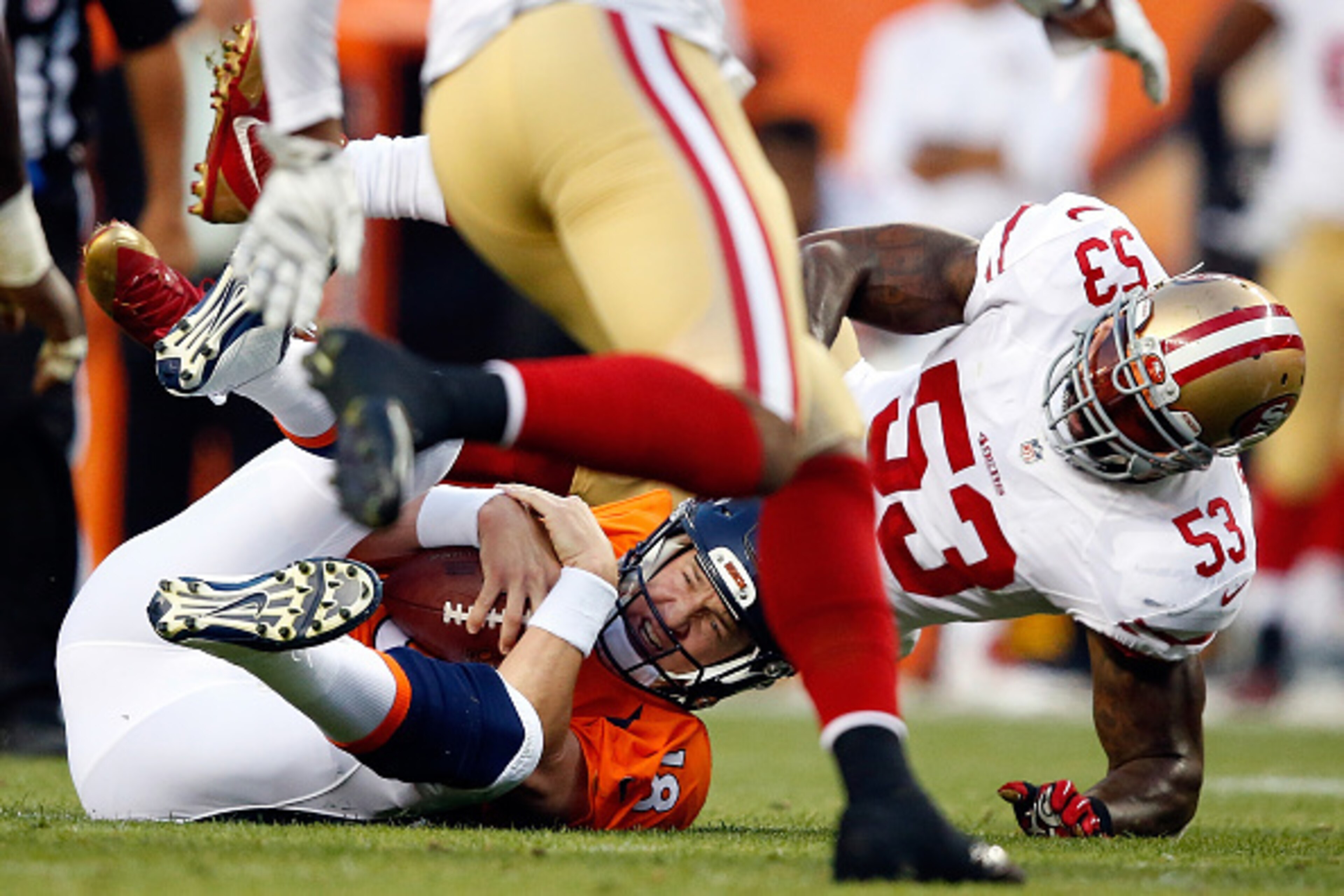 DENVER, CO - AUGUST 29:  Quarterback Peyton Manning #18 of the Denver Broncos is sacked by inside linebacker NaVorro Bowman #53 of the San Francisco 49ers during preseason action at Sports Authority Field at Mile High on August 29, 2015 in Denver, Colorad