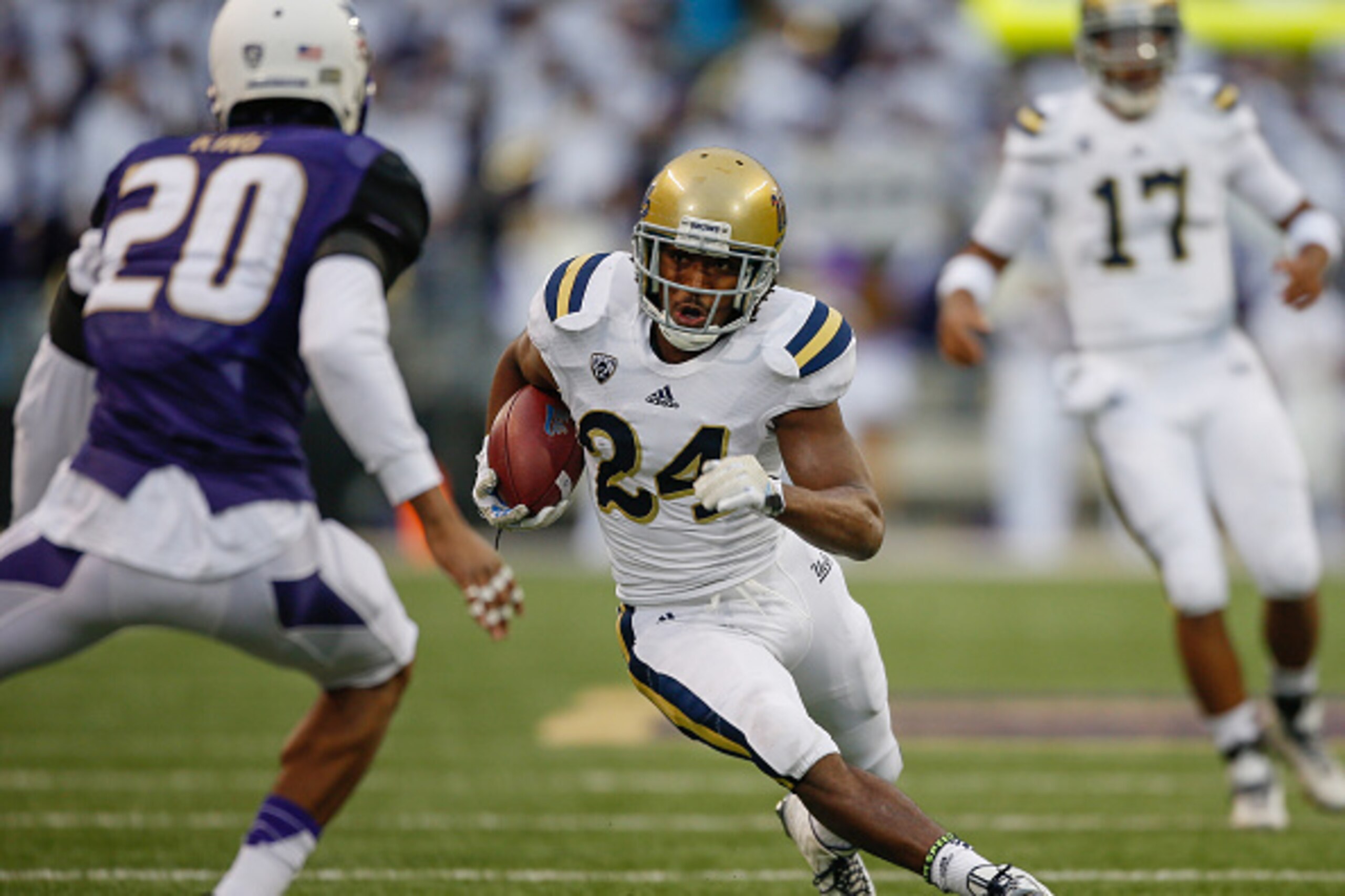 SEATTLE, WA - NOVEMBER 08:  Running back Paul Perkins #24 of the UCLA Bruins rushes against defensive back Kevin King #20 of the Washington Huskies on November 8, 2014 at Husky Stadium in Seattle, Washington.  (Photo by Otto Greule Jr/Getty Images)