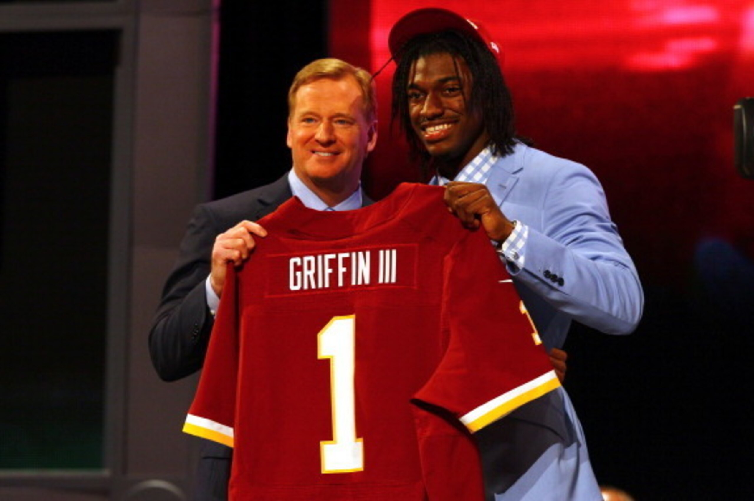 NEW YORK, NY - APRIL 26:  Robert Griffin III (R) from Baylor holds up a jersey as he stands on stage with NFL Commissioner Roger Goodell after Griffin was selected #2 overall by the Washington Redskins in the first round of the 2012 NFL Draft at Radio Cit