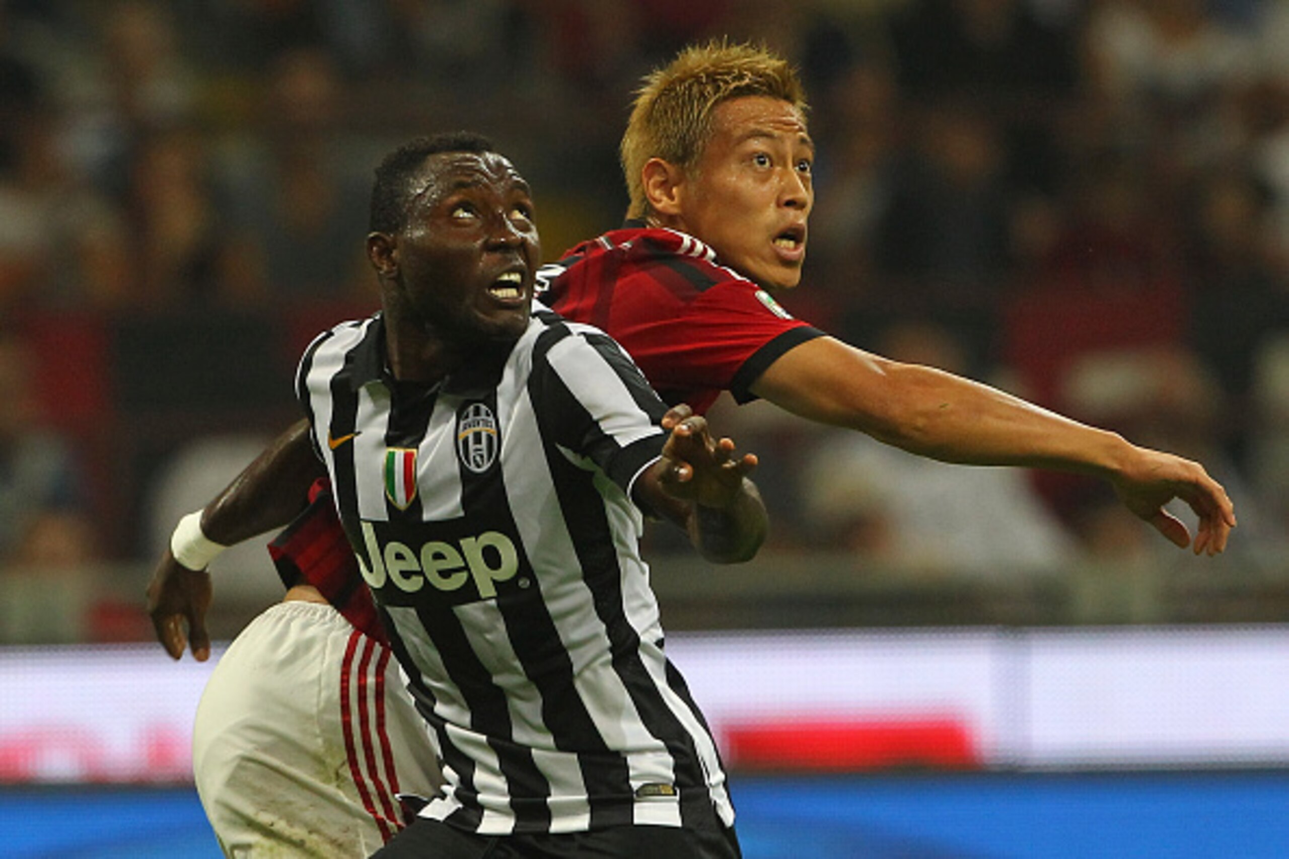 MILAN, ITALY - SEPTEMBER 20:  Kwadwo Asamoah of Juventus FC competes with Keisuke Honda of AC Milan during the Serie A match between AC Milan and Juventus FC at Stadio Giuseppe Meazza on September 20, 2014 in Milan, Italy.  (Photo by Marco Luzzani/Getty I