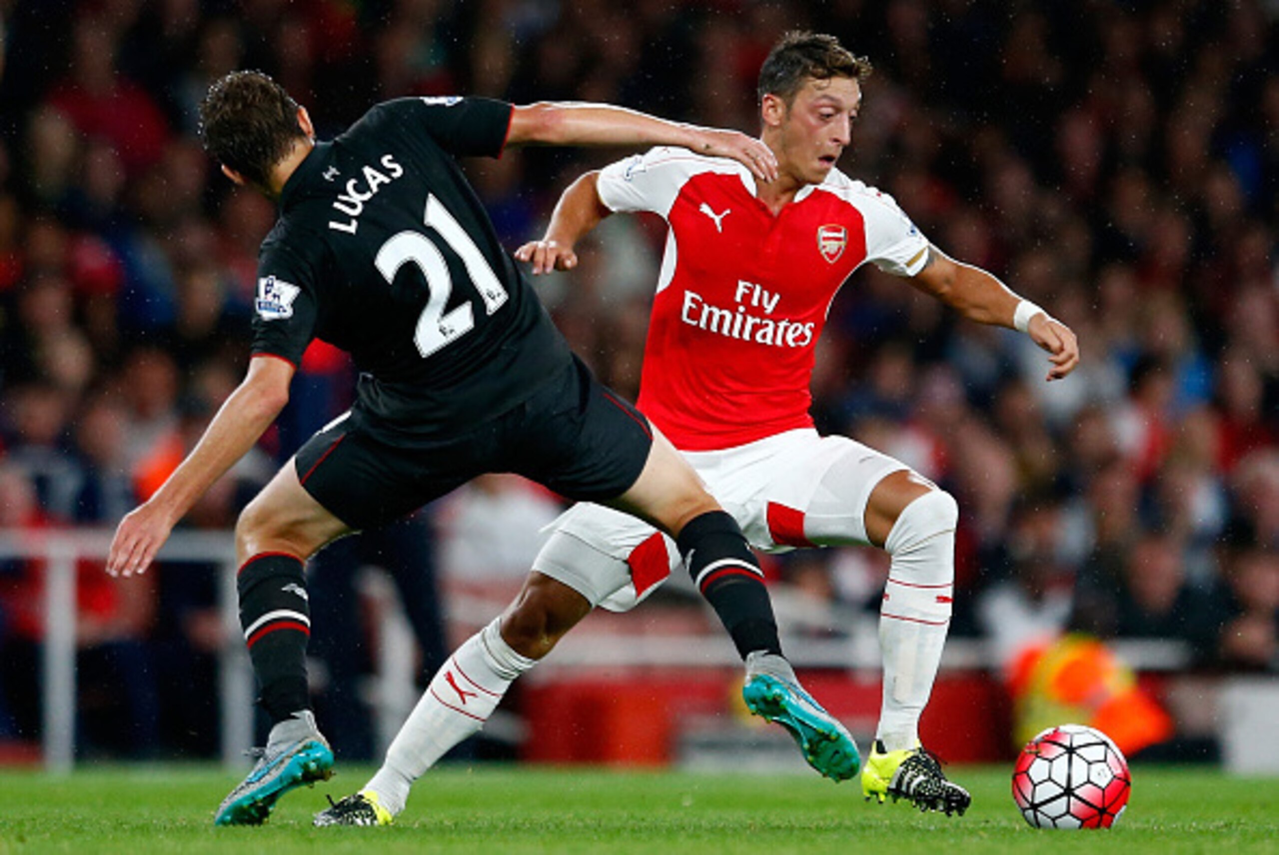 LONDON, ENGLAND - AUGUST 24:  Mesut Oezil of Arsenal takes on Lucas Leiva of Liverpool during the Barclays Premier League match between Arsenal and Liverpool at the Emirates Stadium on August 24, 2015 in London, United Kingdom.  (Photo by Julian Finney/Ge