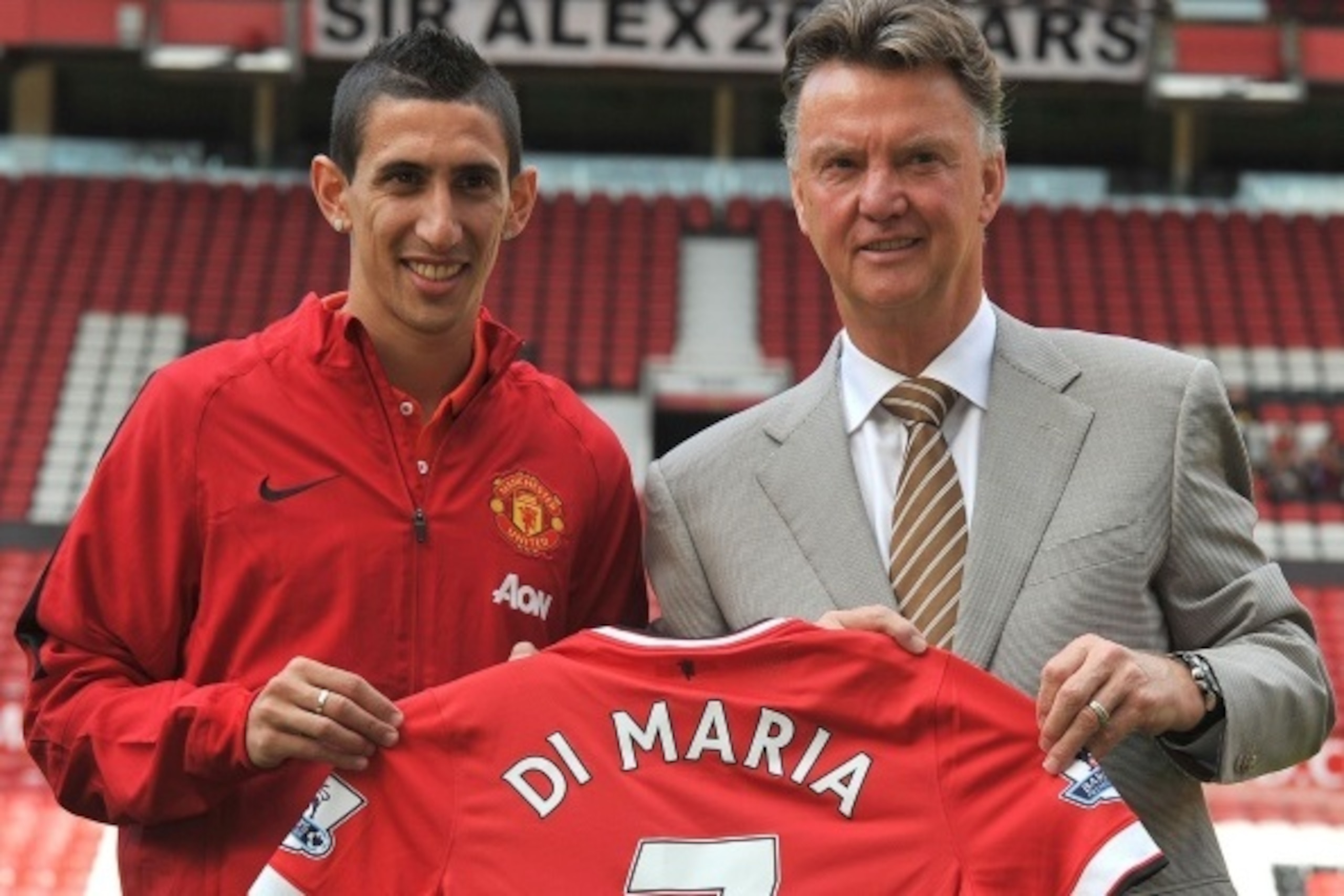 Manchester United's Dutch manager Louis van Gaal (R) and Manchester United's newly-signed Argentinian midfielder Angel di Maria (L) pose with his number 7 shirt during an official presentation on the pitch at Old Trafford in Manchester, north-west England