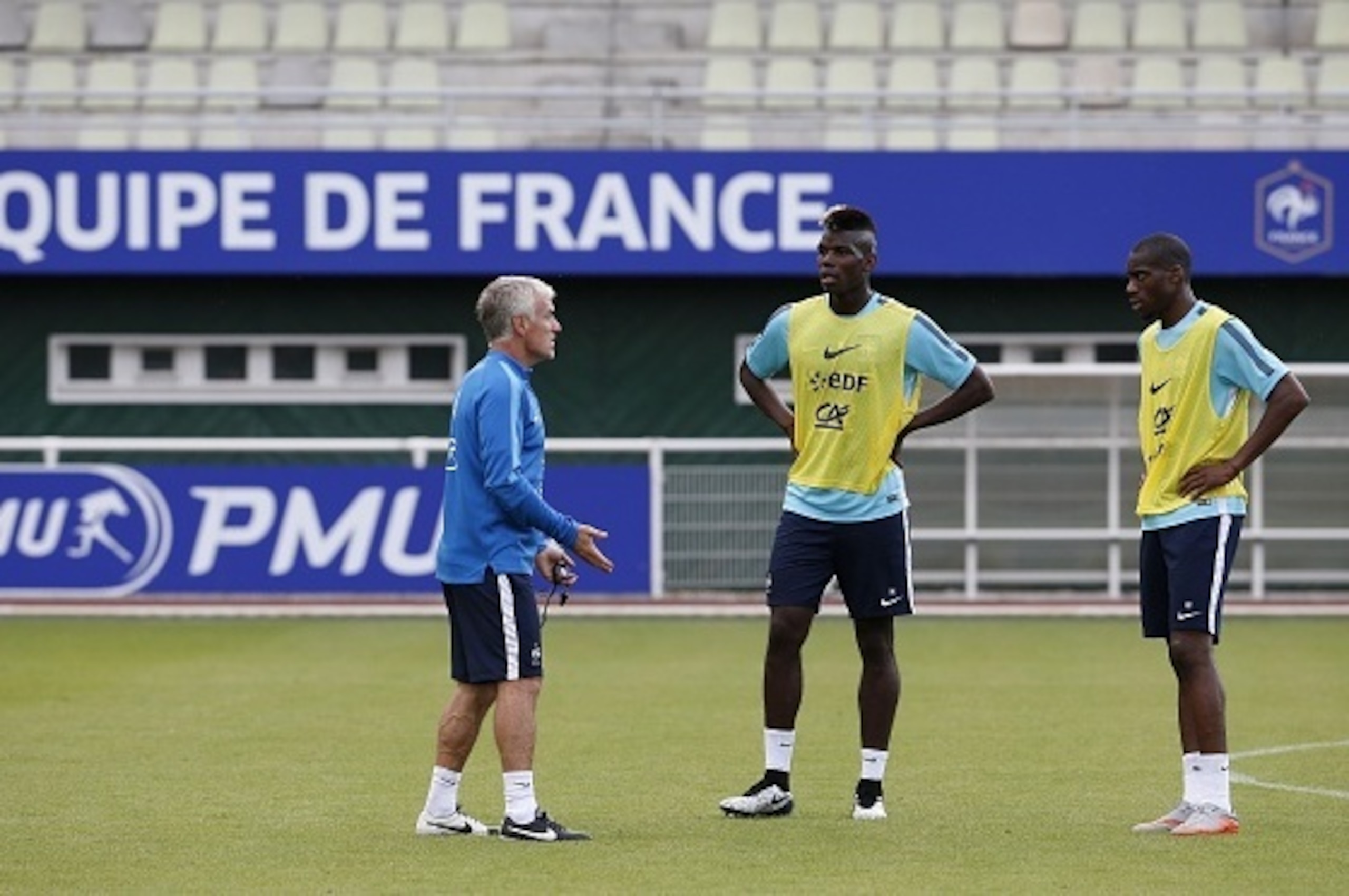 France's head coach Didier Deschamps (L) speaks to France's midlefielders Paul Pogba (C) and Geoffrey Kondogbia during a training session in Clairefontaine-en-Yvelines on June 10, 2015 ahead of a friendly football match against Albania to be held on June 
