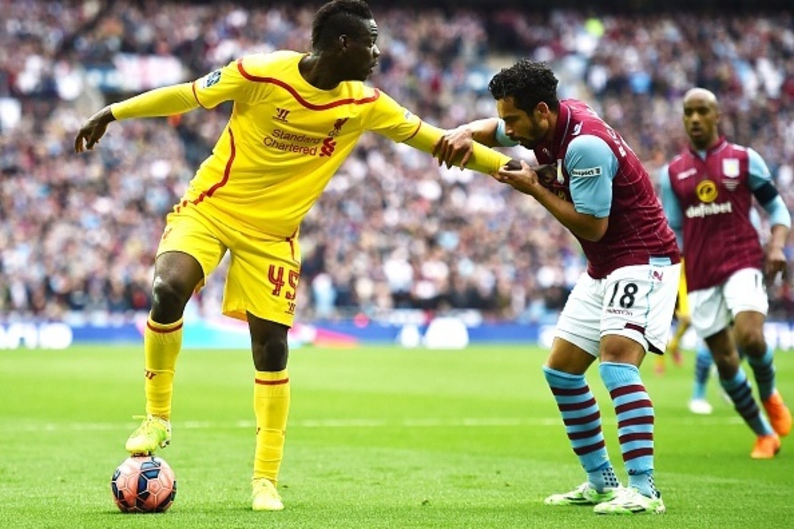 Liverpool's Italian striker Mario Balotelli (L) holds off Aston Villa's English defender Kieran Richardson during the FA Cup semi-final between Aston Villa and Liverpool at Wembley stadium in London on April 19, 2015.
AFP PHOTO / BEN STANSALL
NOT FOR MARK