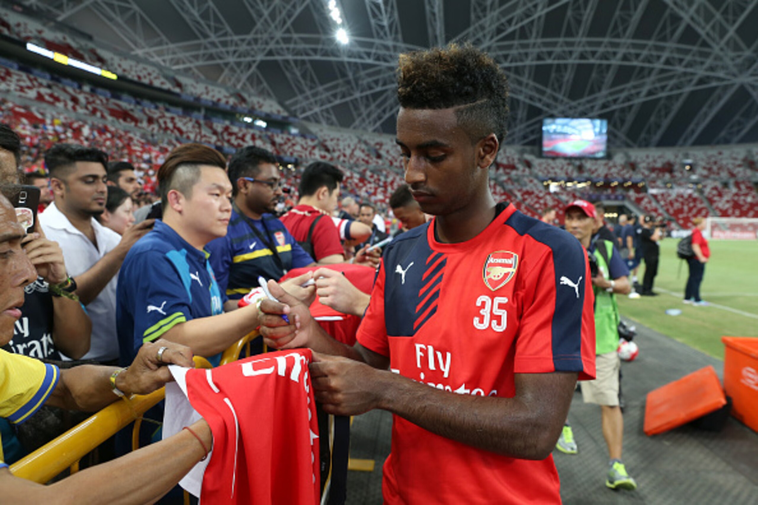 SINGAPORE - JULY 14:  Gedion Zelalem of Arsenal signs autographs for fans during the open Barclays Asia Trophy training session at the National Stadium on July 14, 2015 in Singapore.  (Photo by Lionel Ng/Getty Images)