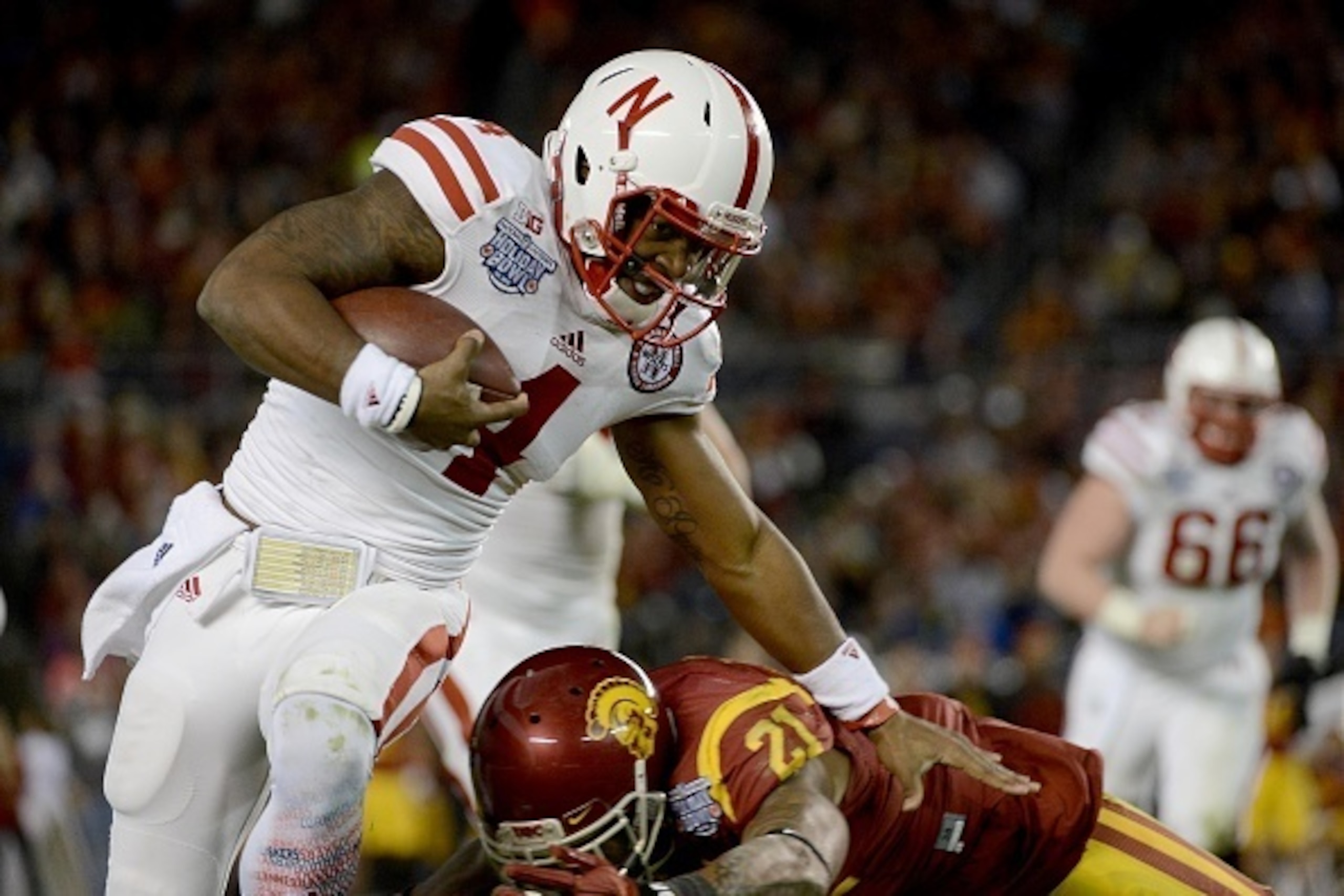 SAN DIEGO, CA-  DECEMBER 27:  Tommy Armstrong Jr. #4 of the Nebraska Cornhuskers runs against the tackle of Su'a Cravens #21 of the USC Trojans during the National University Holiday Bowl on December 27, 2014 at Qualcomm Stadium in San Diego, California. 